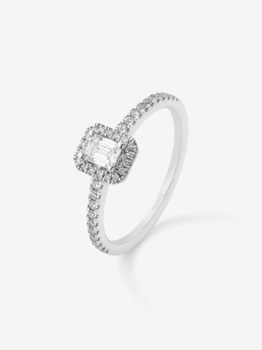 Anillo de oro blanco de 18K con diamante en talla esmeralda de 0,24 cts y orla de diamantes en talla brillante con un total de 0,17 cts