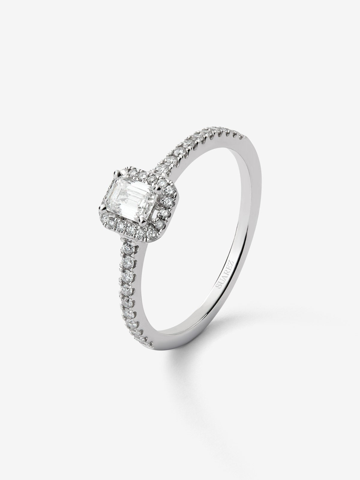 Anillo de oro blanco de 18K con diamante en talla esmeralda de 0,50 cts y orla de diamantes en talla brillante