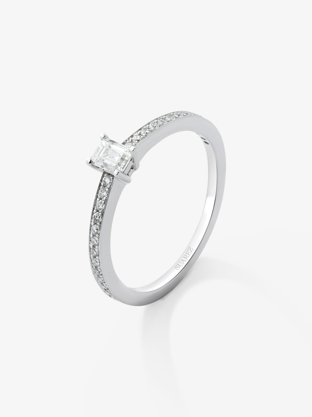 Anillo de oro blanco de 18K con diamante central en talla esmeralda de 0,25 y brazo de 16 diamantes en talla brillante