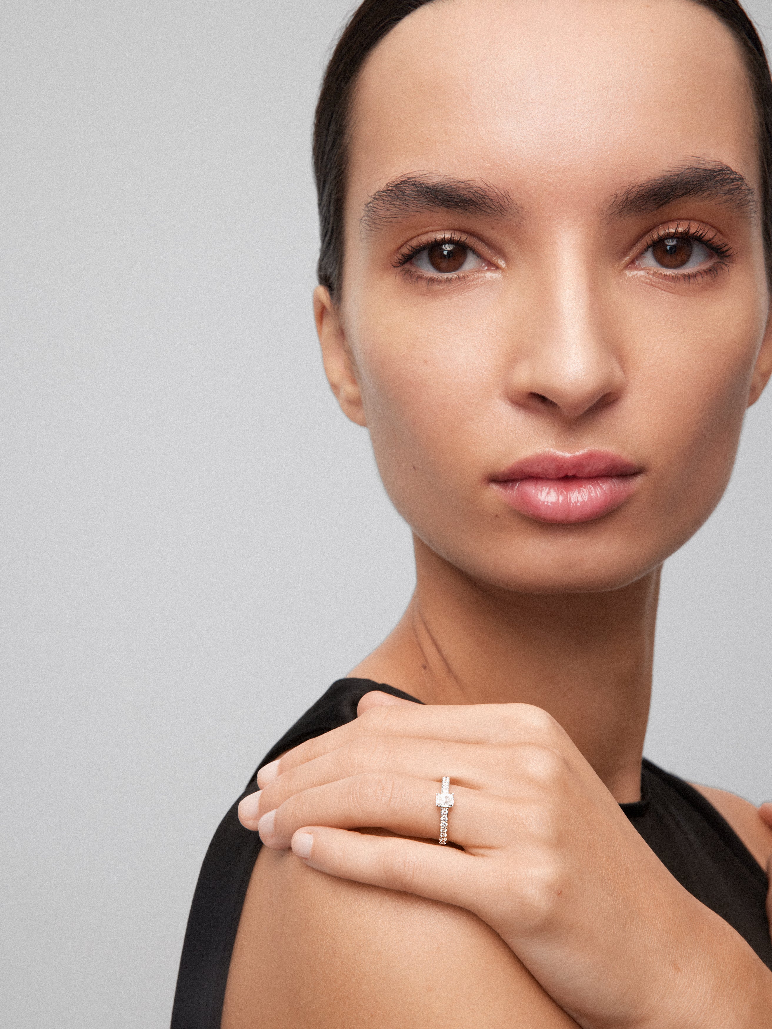 Anillo de oro blanco de 18K con diamante central en talla esmeralda de 0,4 cts y brazo de 26 diamantes en talla brillante con un total de 0,26 cts