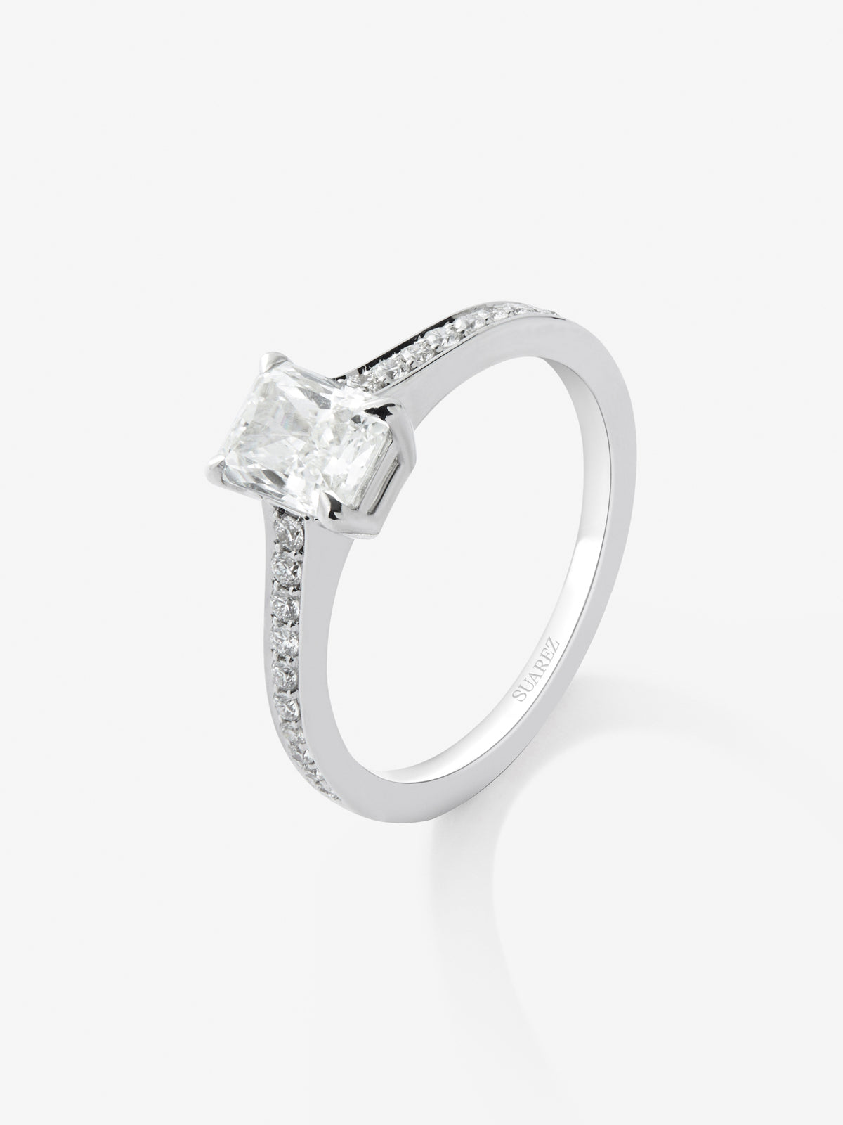 Anillo solitario de oro blanco de 18K con diamante central en talla radiante de 1 cts y 26 diamantes en talla brillante con un total de 0,16 cts