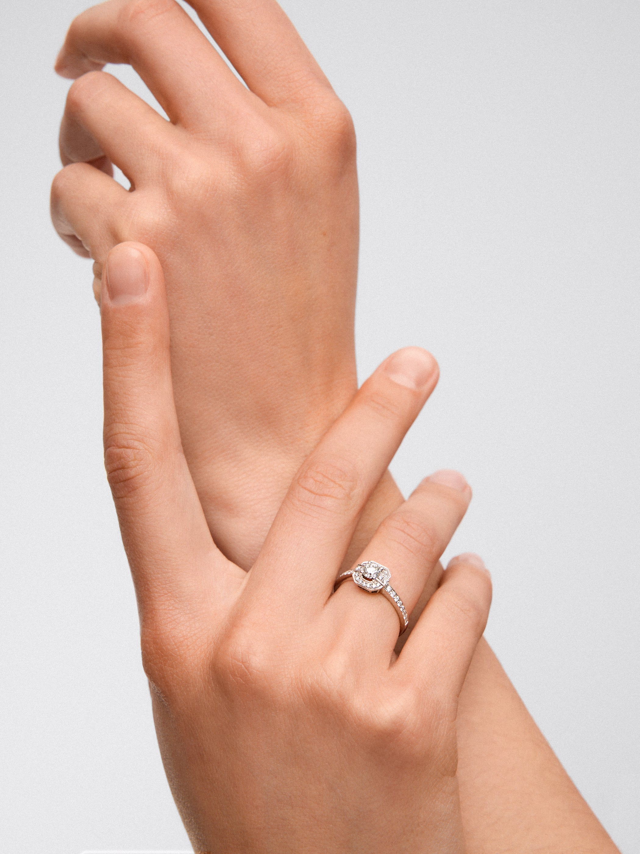 Anillo de oro blanco de 18K con diamante central en talla brillante de 0,3 cts y orla y brazo de 34 diamantes en talla brillante con un total de 0,22 cts