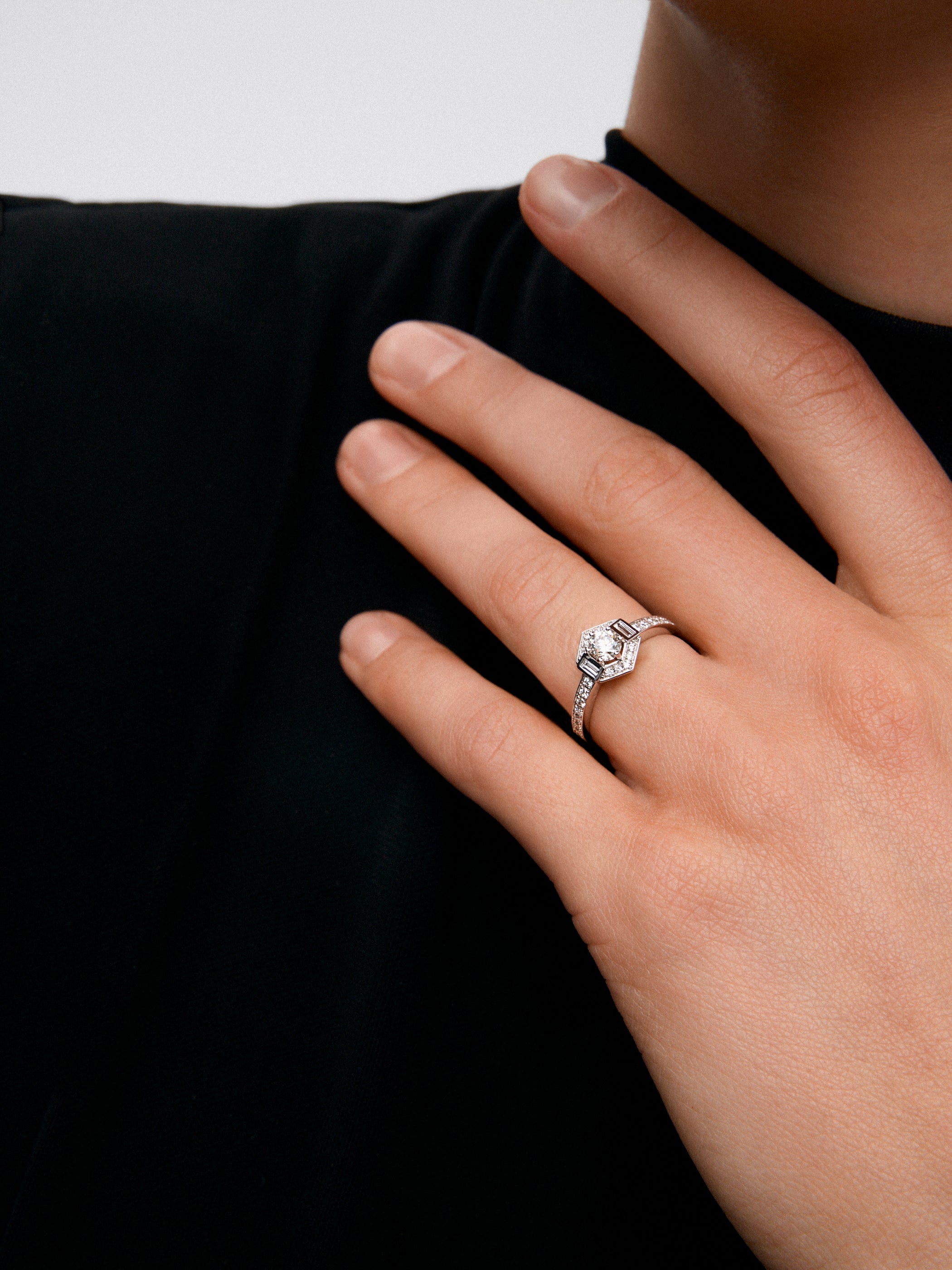 Anillo de oro blanco de 18K con un diamante central en talla brillante de 0,31 cts; 2 en talla baguette con un total de 0,085 cts y 26 en talla brillante con un total de 0,175cts