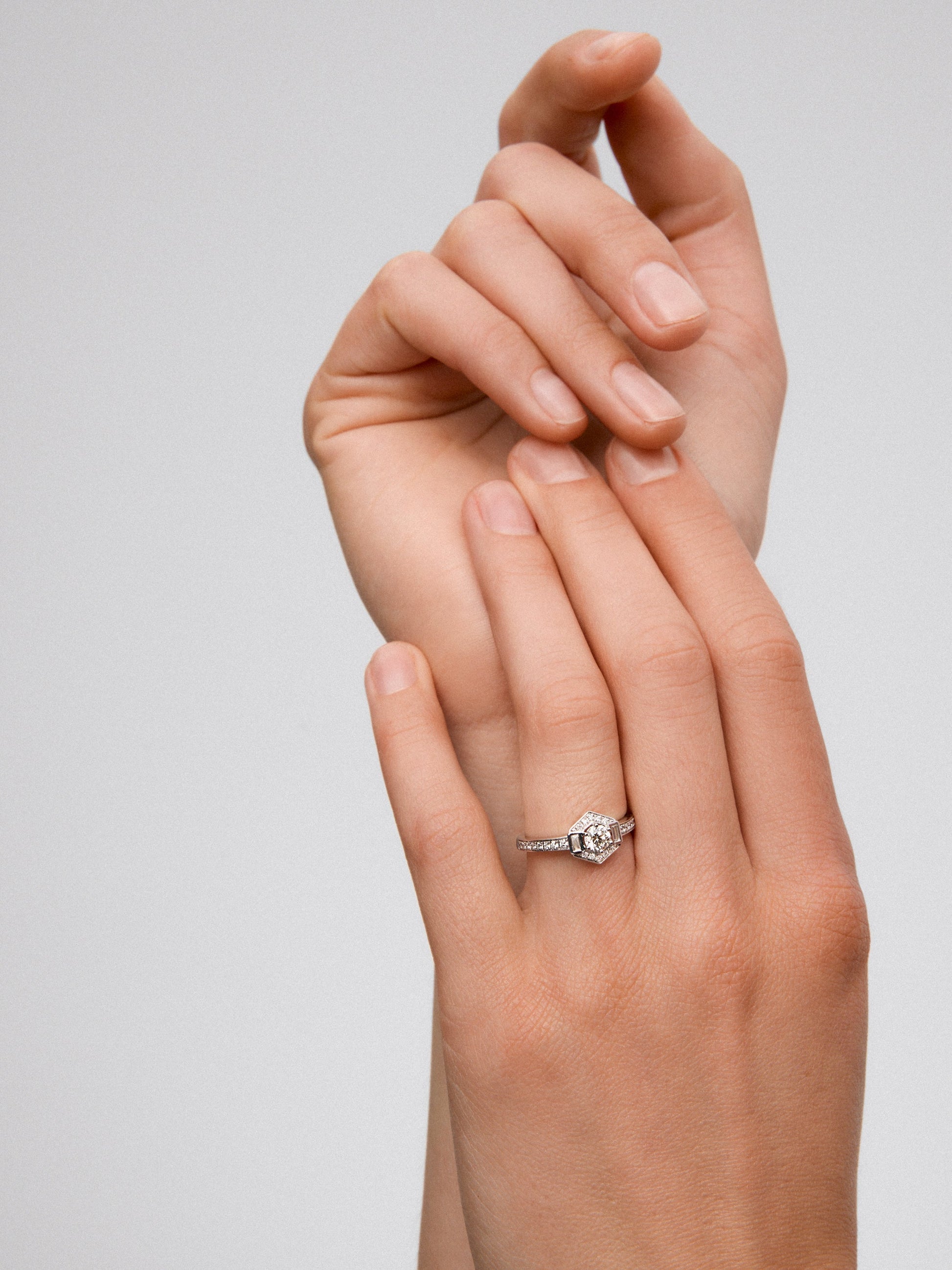 Anillo de oro blanco de 18K con un diamante central en talla brillante de 0,31 cts; 2 en talla baguette con un total de 0,085 cts y 26 en talla brillante con un total de 0,175cts