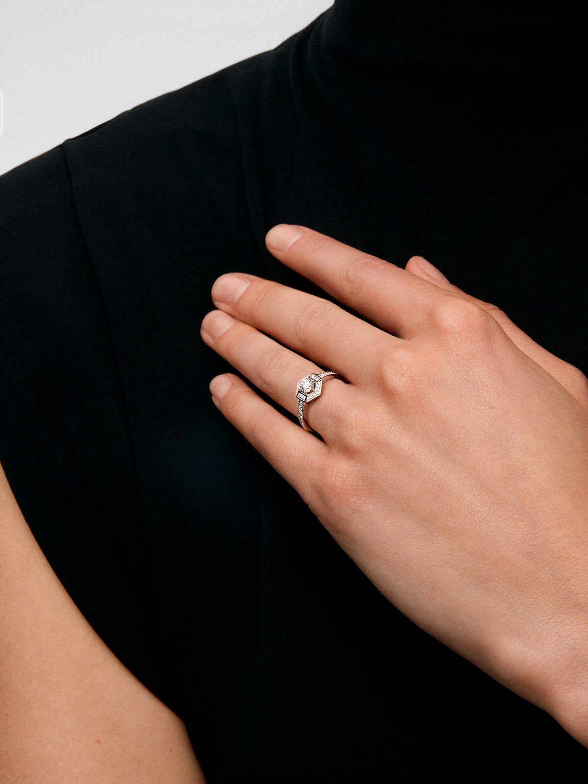 Anillo de oro blanco de 18K con diamante central en talla brillante de 0,4 cts y orla con 2 diamantes en talla baguette con un total de 0,14 cts y 30 en talla brillante con un total de 0,19 cts