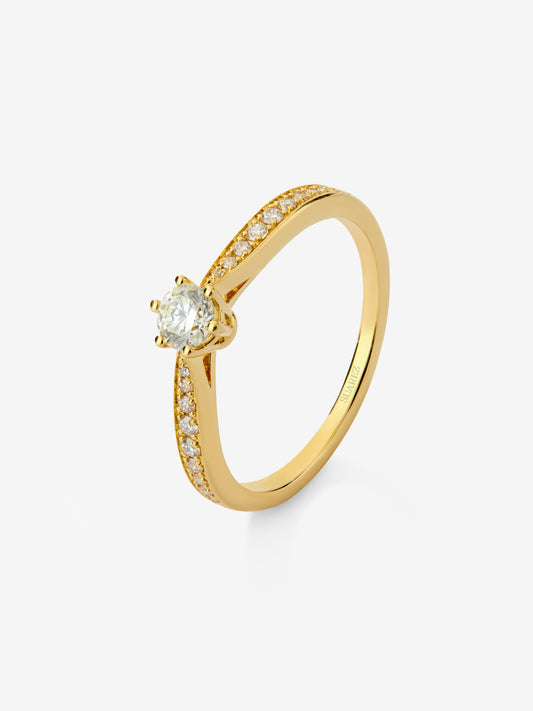 Anillo solitario 3006 de oro amarillo de 18K con diamante central en talla brillante de 0,20 cts y diamantes en talla brillante con un total de 0,10 cts