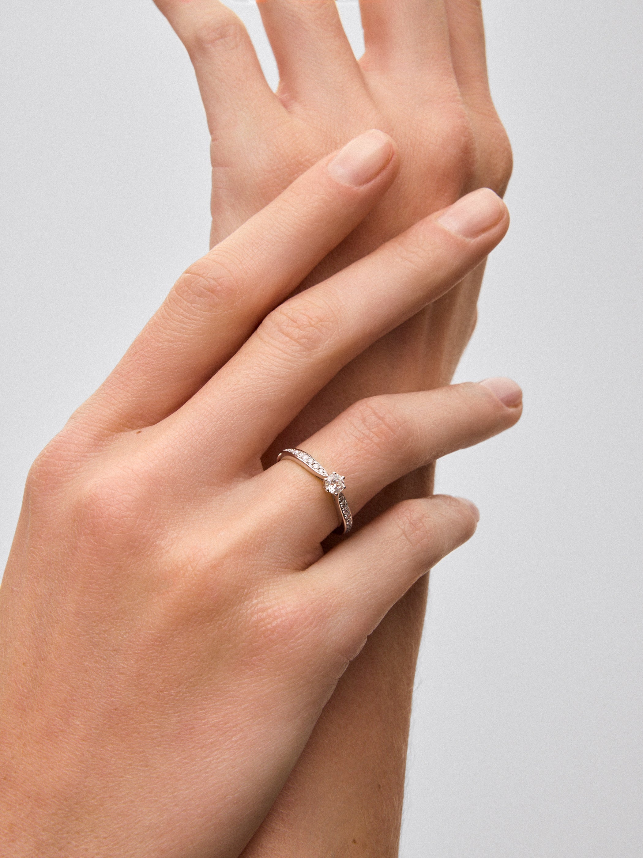 Anillo solitario 3006 de oro blanco de 18K con diamante central en talla brillante de 0,20 cts y diamantes en talla brillante con un total de 0,11 cts