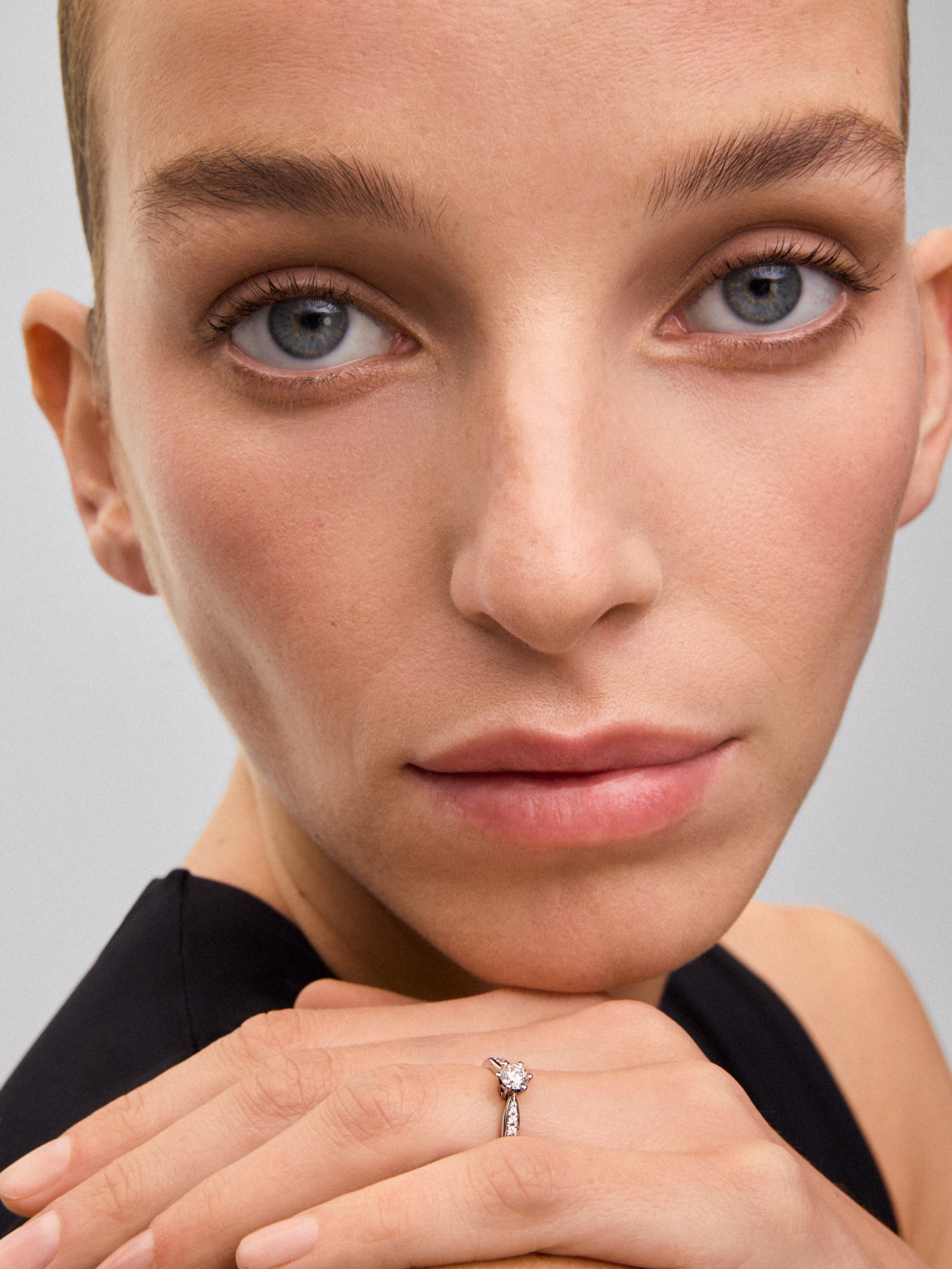 Anillo solitario de oro blanco de 18K con diamante central en talla brillante de 0,32 cts y diamantes en talla brillante con un total de 0,15 cts