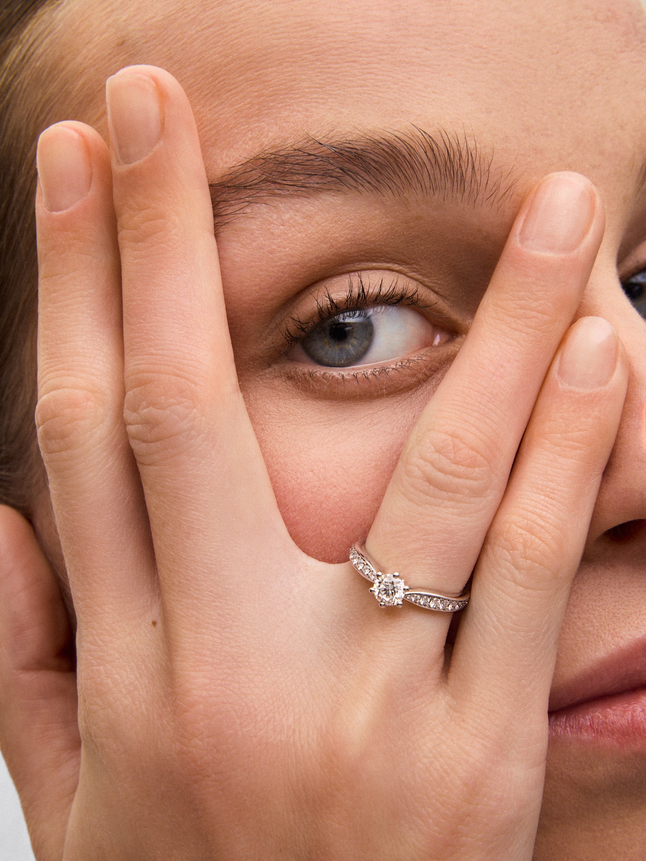 Anillo solitario de oro blanco de 18K con diamante central en talla brillante de 0,50 cts y diamantes en talla brillante con un total de 0,23 cts