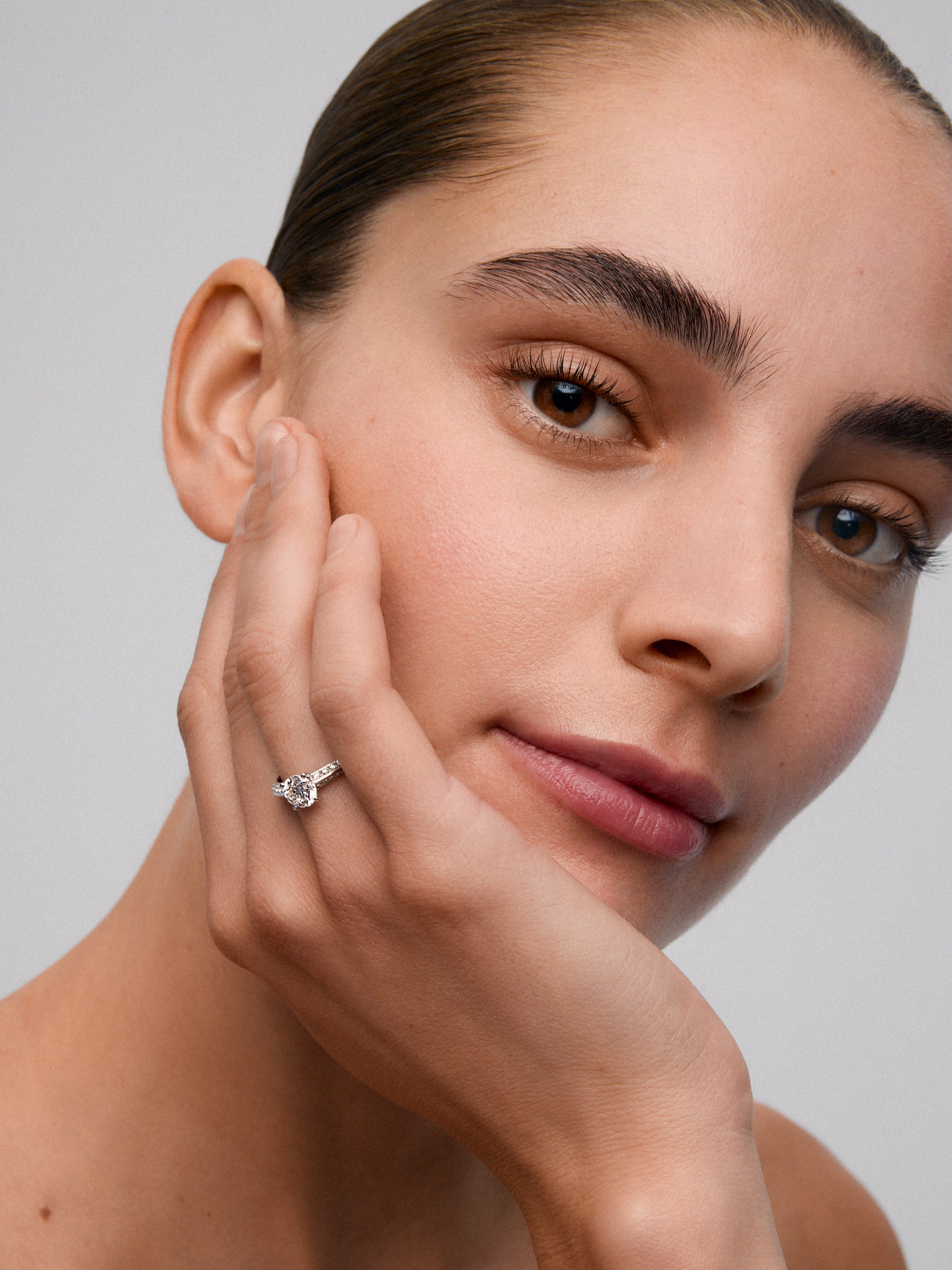 Anillo solitario de oro blanco de 18K con diamante central en talla brillante de 0,50 cts y diamantes en talla brillante con un total de 0,23 cts