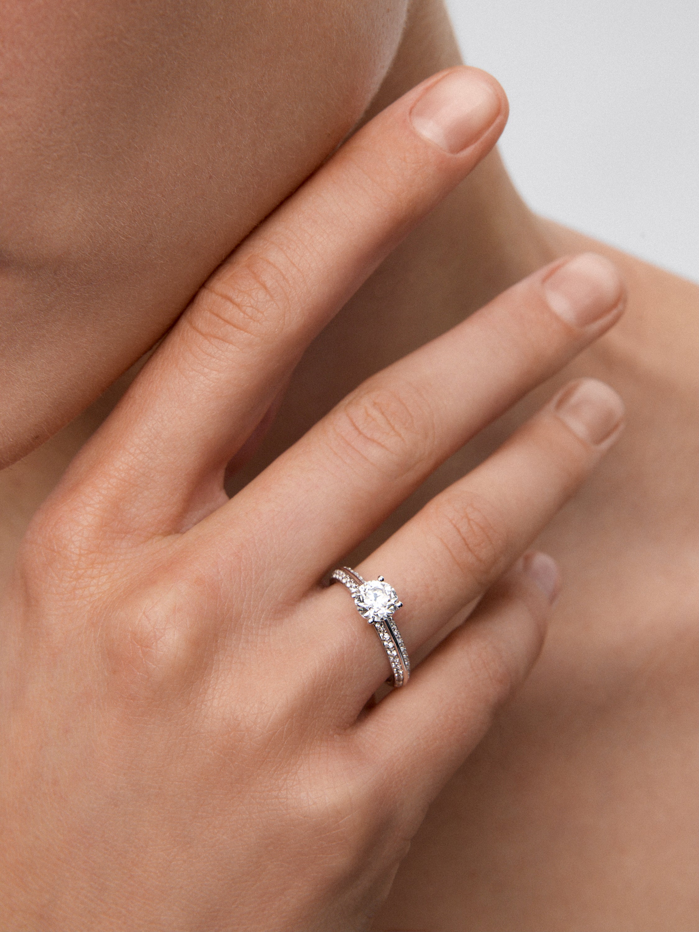 Anillo solitario de oro blanco de 18K con diamante central en talla brillante de 0,50 cts y diamantes en talla brillante con un total de 0,23 cts