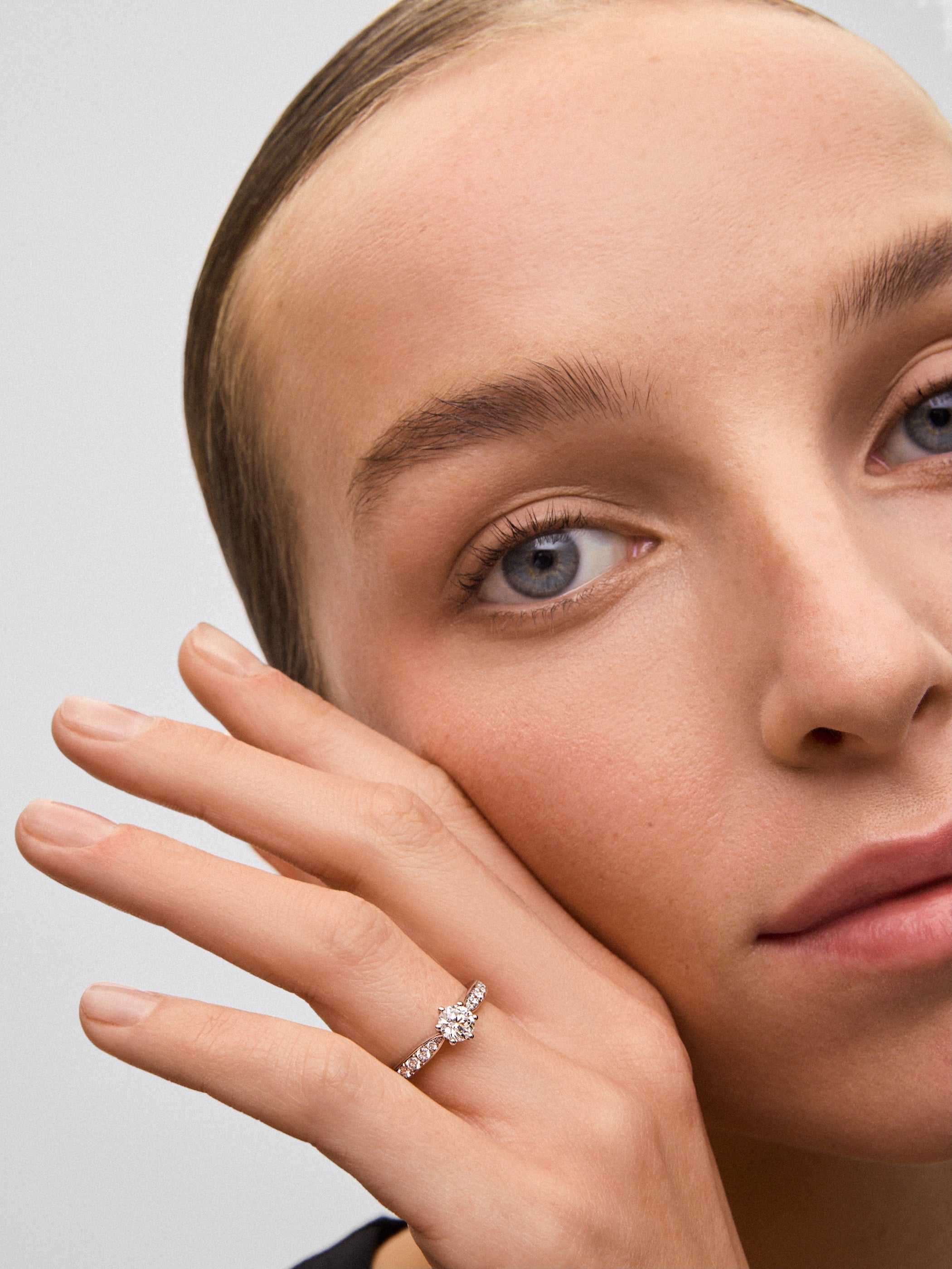 Anillo solitario de oro blanco de 18K con diamante central en talla brillante de 0,70 cts y diamantes en talla brillante con un total de 0,30 cts