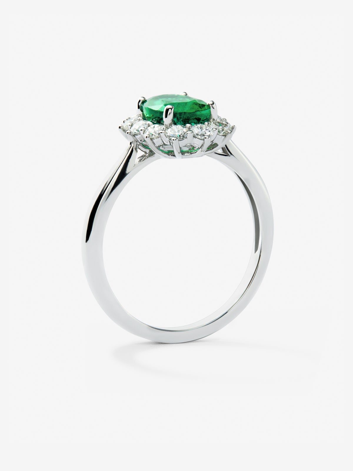 Anillo de oro blanco de 18K con esmeralda verde vivid en talla oval de 1,26 cts y 12 diamantes en talla brillante con un total de 0,45 cts