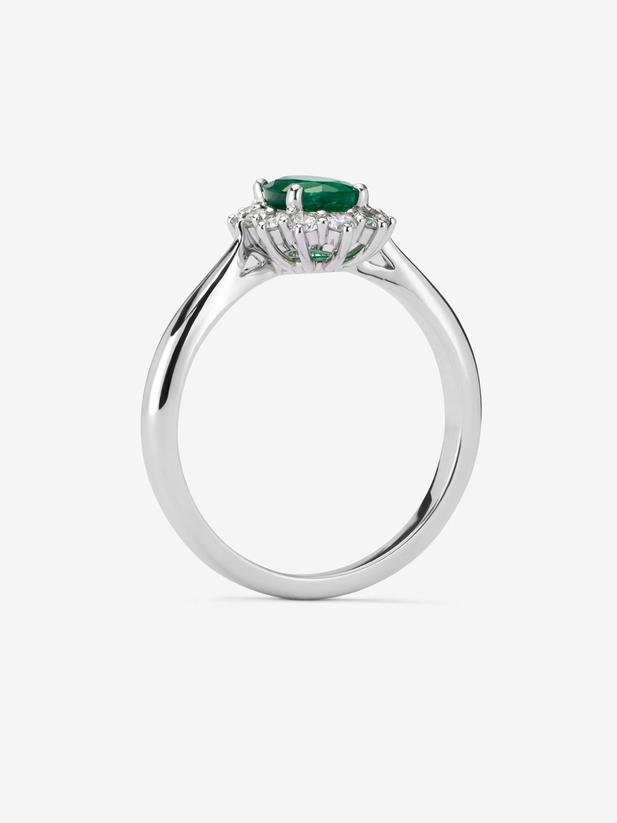 Anillo de oro blanco de 18K con esmeralda central en talla oval de 0,78 cts y orla de diamantes en talla brillante con un total de 0,42 cts