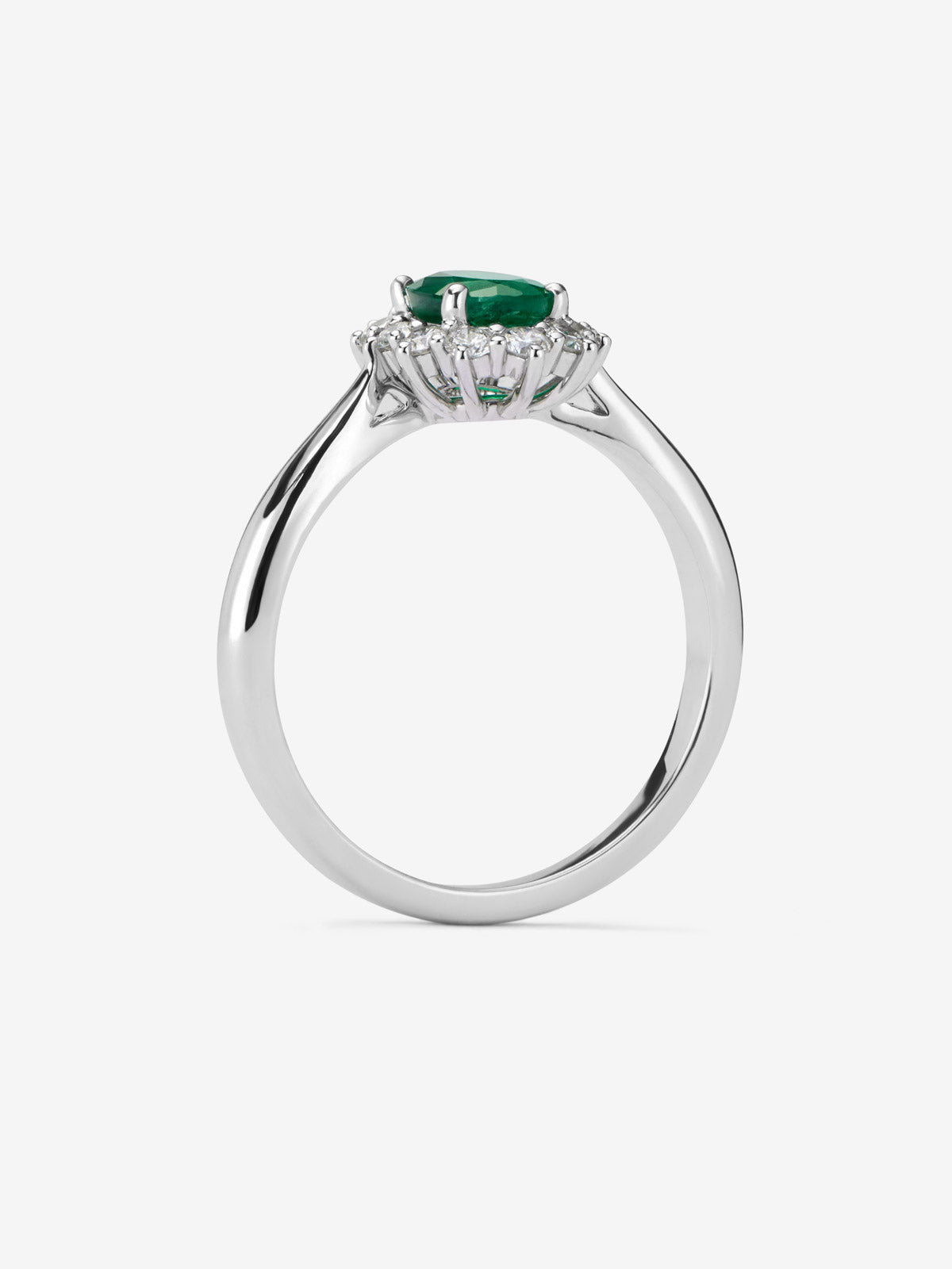 Anillo de oro blanco de 18K con esmeralda central en talla oval de 0,70 cts y orla de diamantes en talla brillante con un total de 0,30 cts