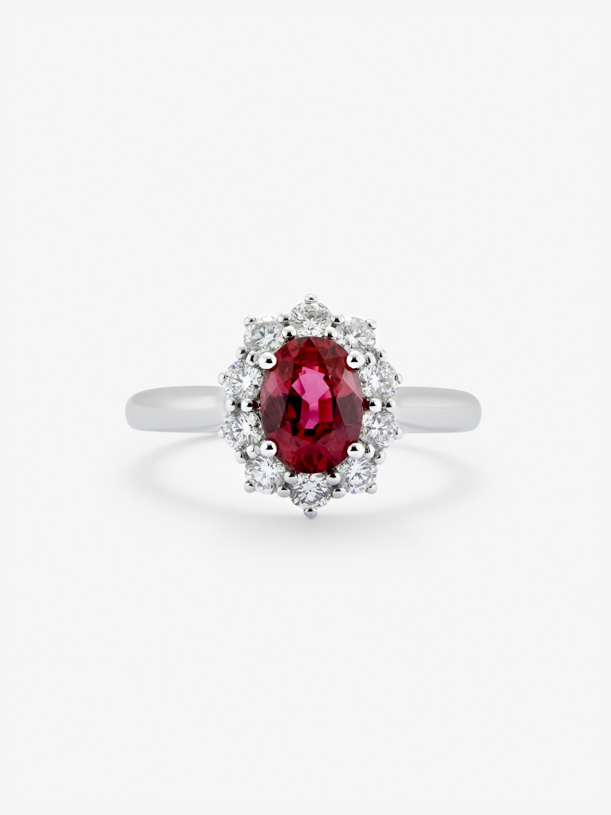 Anillo de oro blanco de 18K con rubí rojo vivid en talla oval de 1 cts y 12 diamantes en talla brillante con un total de 0,25 cts