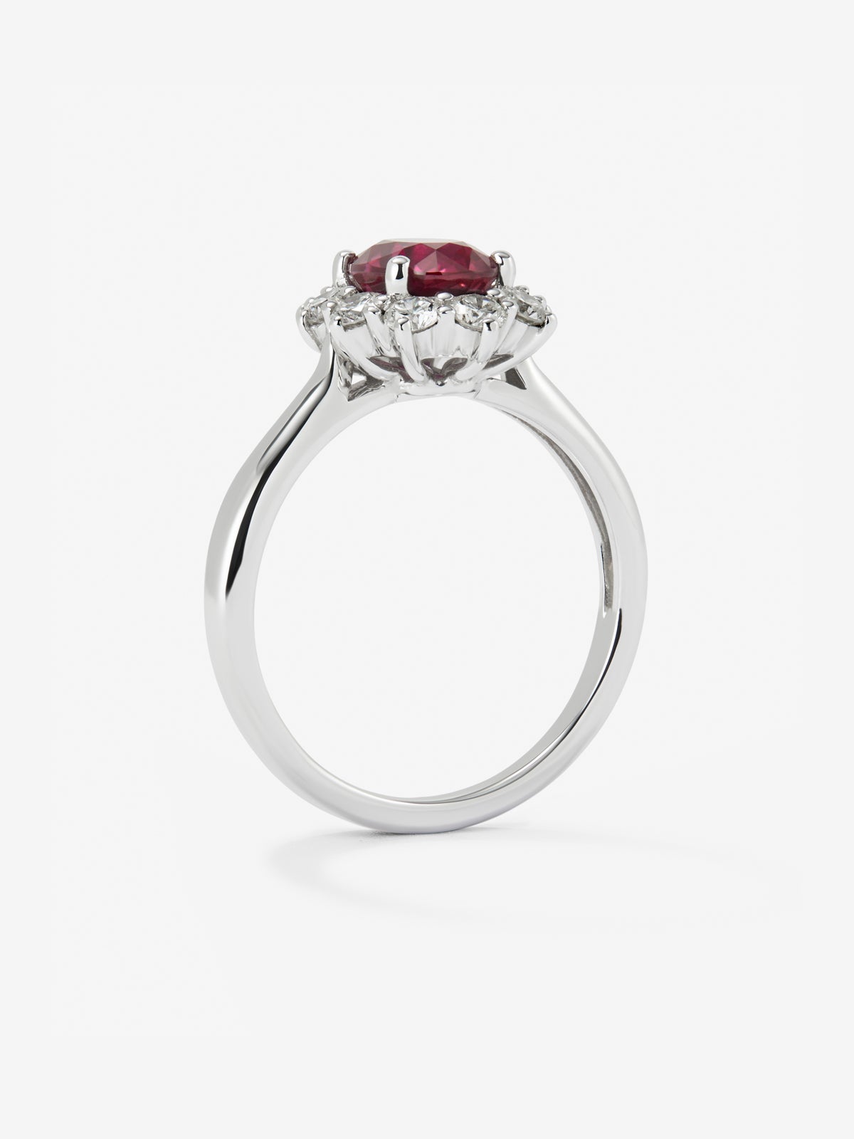 Anillo de oro blanco de 18K con rubí rojo vivid en talla oval de 1 cts y 12 diamantes en talla brillante con un total de 0,25 cts