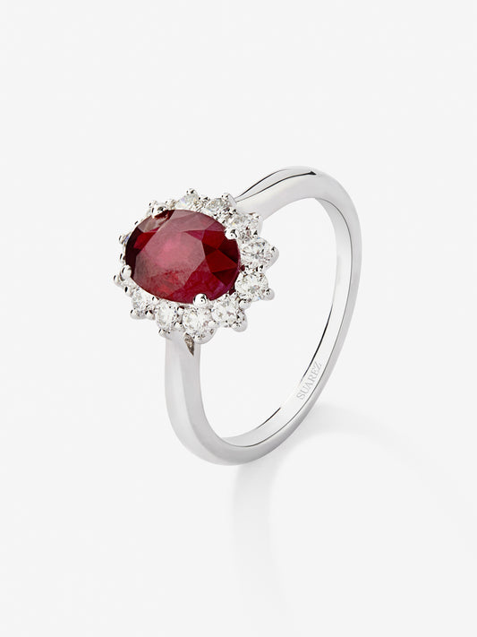 Anillo de oro blanco de 18K con rubí rojo vivid en talla oval de 1 cts y 12 diamantes en talla brillante con un total de 0,25 cts