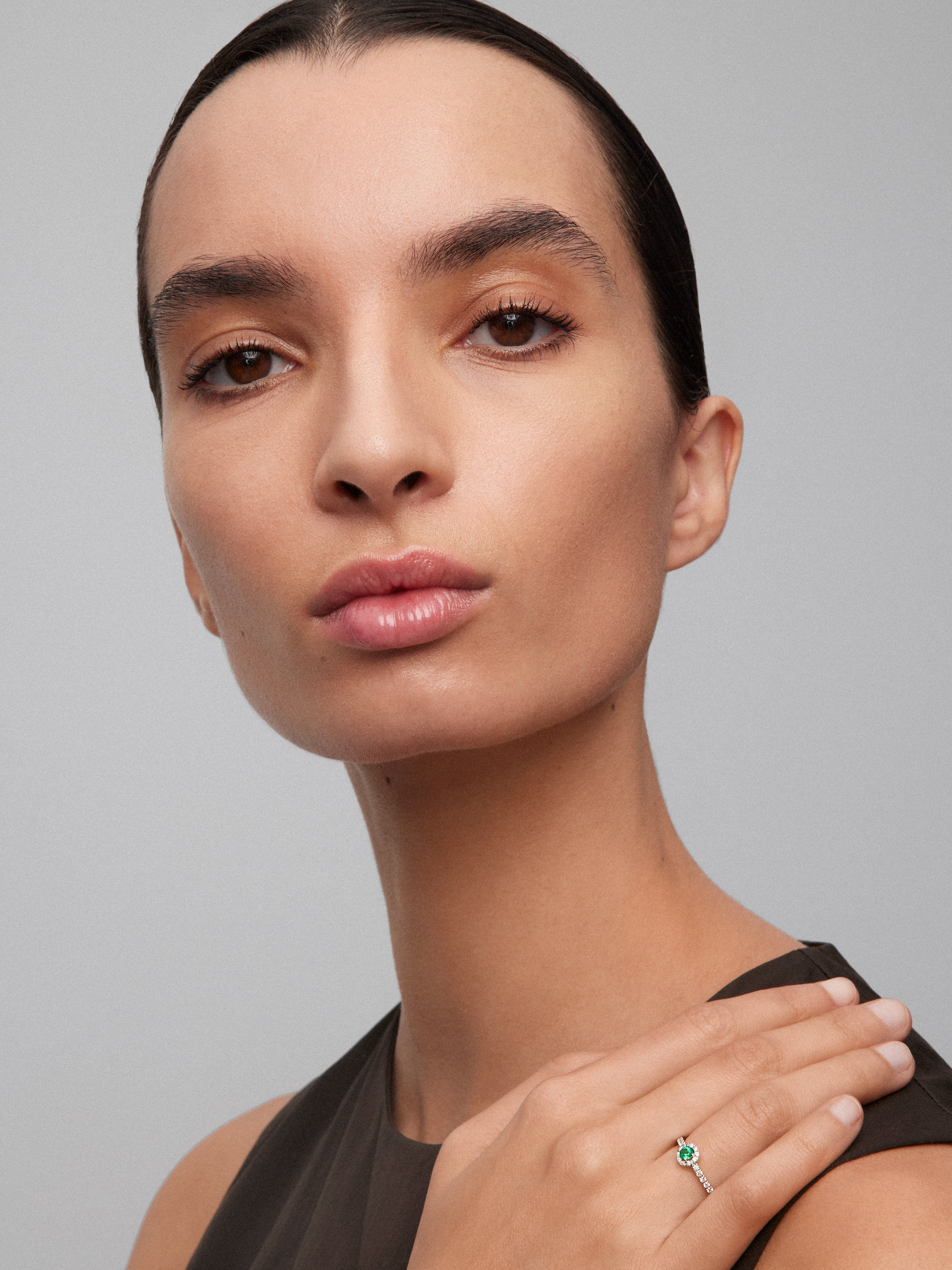 18K white gold ring with brilliant-cut emerald of 0.15 cts and arm and border of 26 brilliant-cut diamonds with a total of 0.27 cts