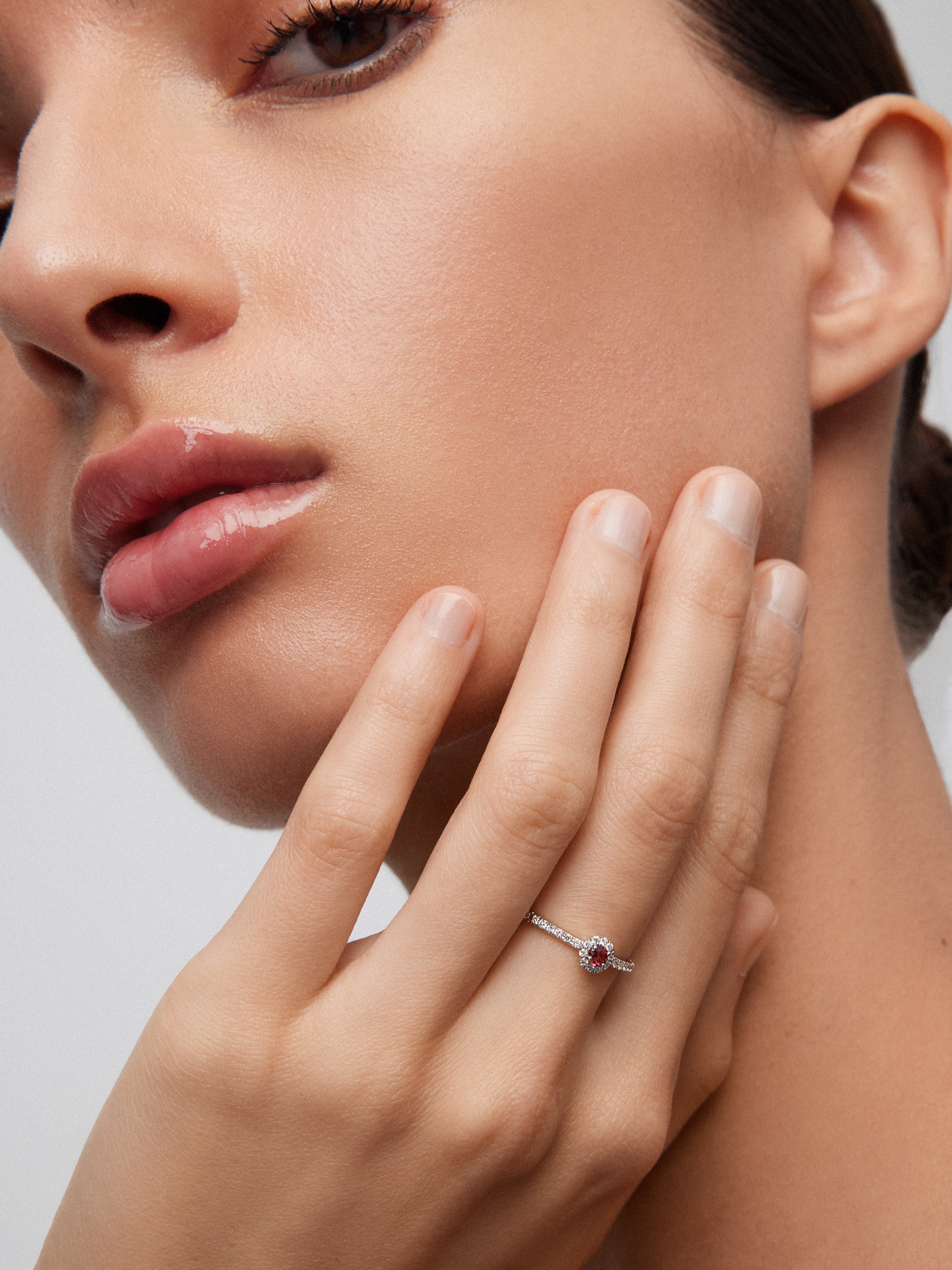 Anillo de oro blanco de 18K con rubí rojo en talla brillante de 0,1 cts y orla y brazo de 28 diamantes en talla brillante con un total de 0,2 cts