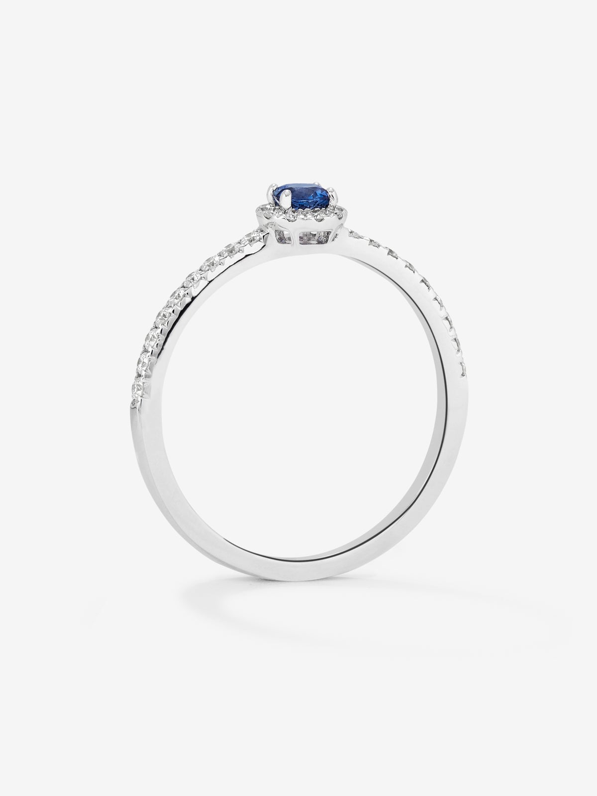 Anillo de oro blanco de 18K con zafiro azul en talla brillante de 0,15 cts y orla y brazo de 28 diamantes en talla brillante con un total de 0,2 cts