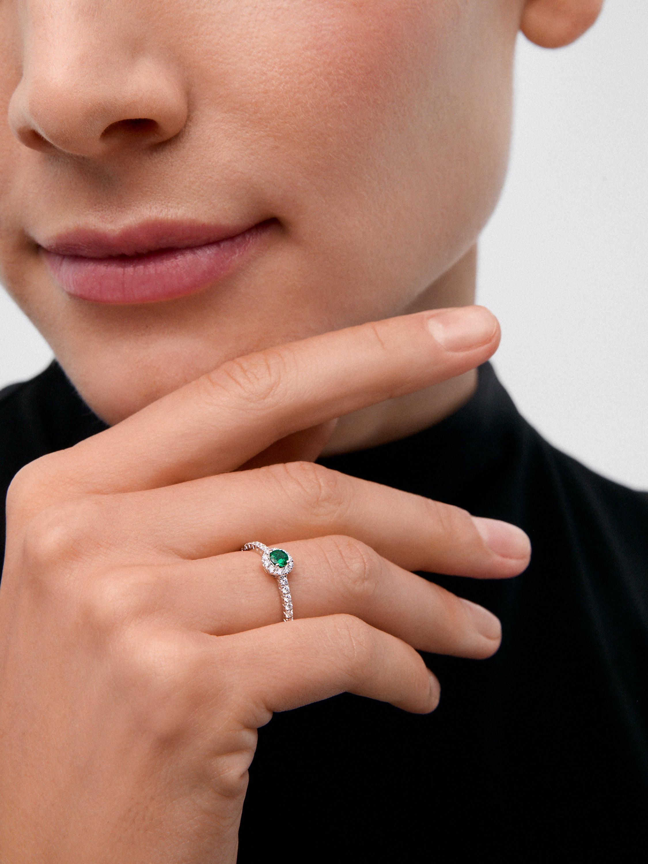Anillo de oro blanco de 18K con esmeralda en talla brillante de 0,1 cts y brazo y orla de diamantes en talla brillante con un total de 0,20 cts
