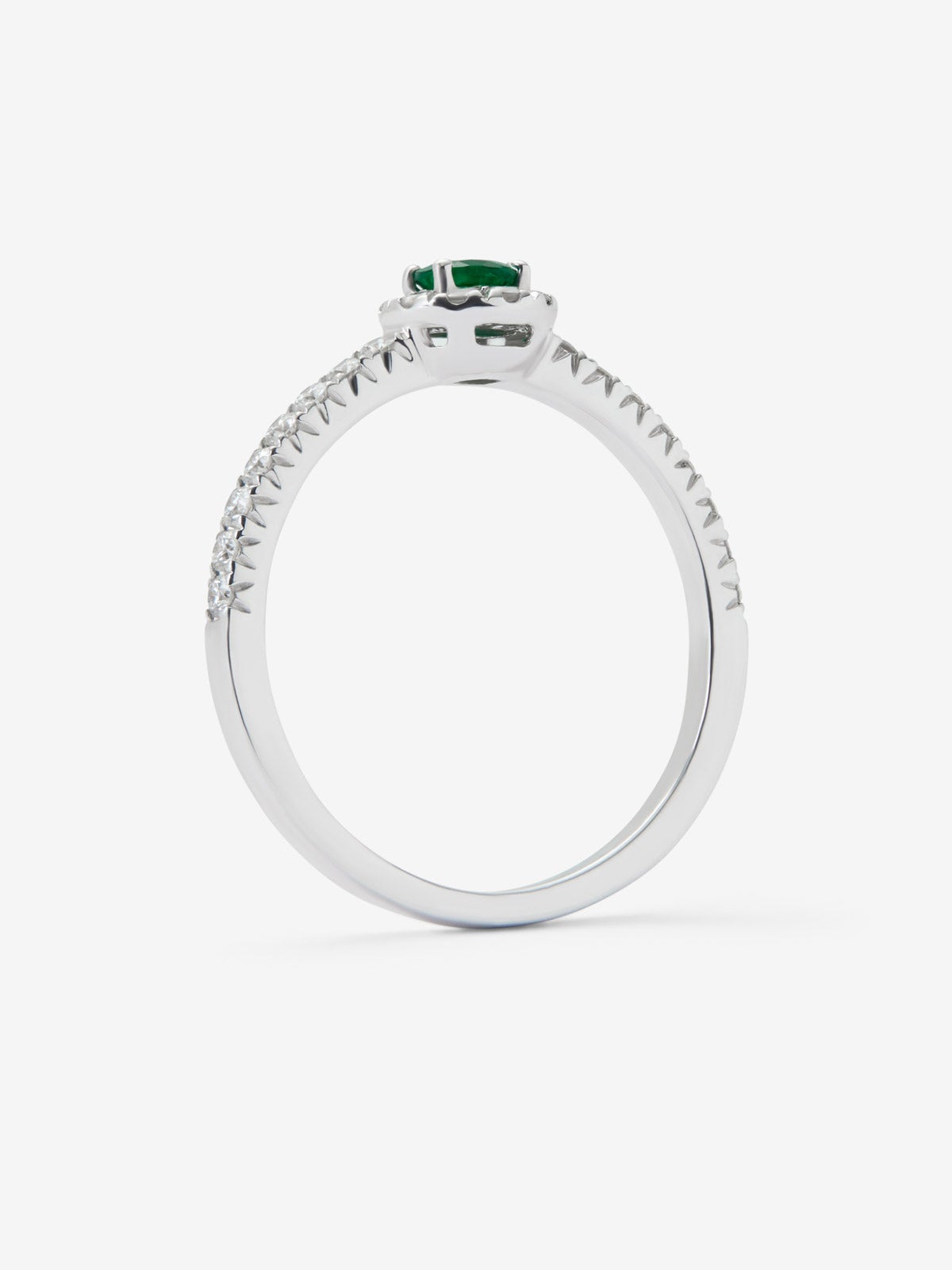 Anillo de oro blanco de 18K con esmeralda en talla brillante de 0,1 cts y brazo y orla de diamantes en talla brillante con un total de 0,20 cts