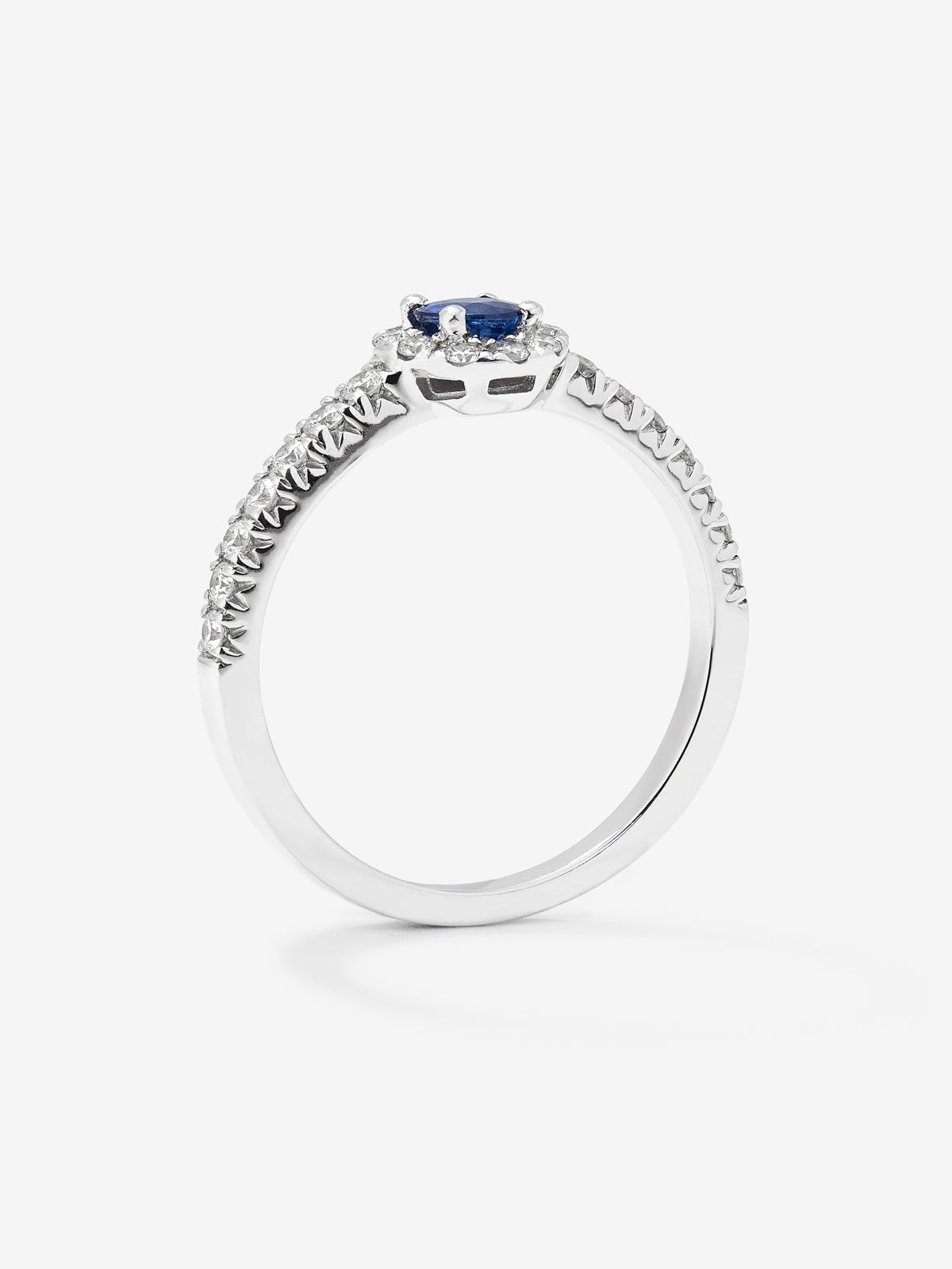 Anillo de oro blanco de 18K con zafiro azul en talla brillante de 0,4 cts y orla y brazo de 24 diamantes en talla brillante con un total de 0,3 cts