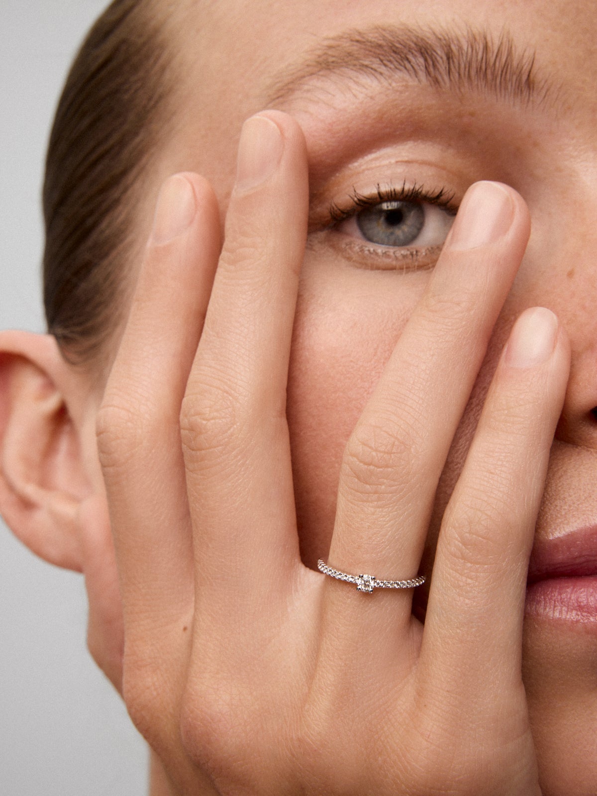 Anillo de oro blanco de 18K con diamante central en talla brillante de 0,12 cts y brazo de 20 diamantes en talla brillante con un total de 0,11 cts