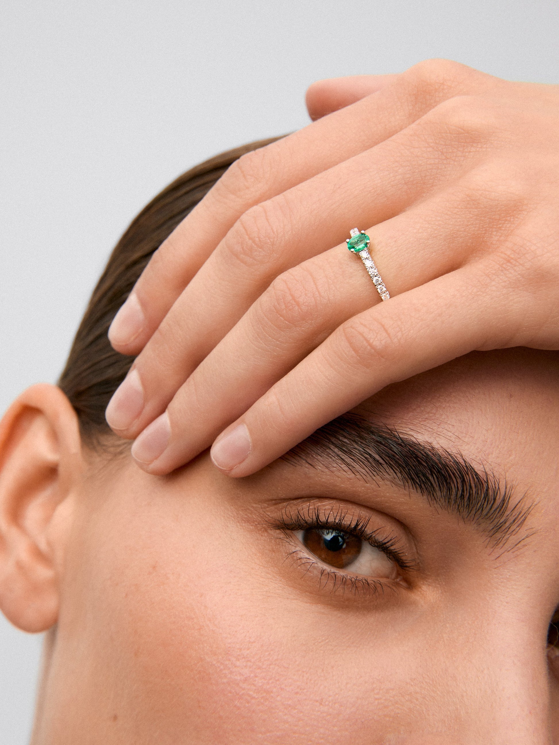 Anillo de oro blanco 18K con esmeralda verde en talla oval de 0,22cts y diamantes