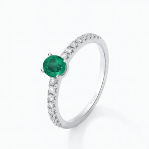 Anillo de oro blanco de 18K con una esmeralda verde en talla oval de 0,70 cts y  diamantes en talla brillante con un total de 0,37cts