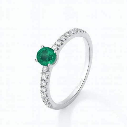 Anillo de oro blanco de 18K con una esmeralda verde en talla oval de 0,30 cts y  diamantes en talla brillante con un total de 0,22cts