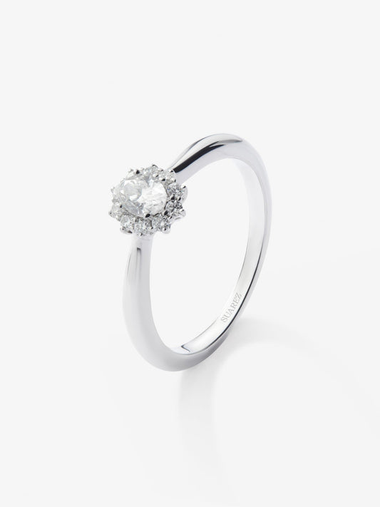 Anillo solitario de oro blanco de 18K con diamante central en talla oval de 0,3 cts y orla de 10 diamantes en talla brillante con un total de 0,18 cts