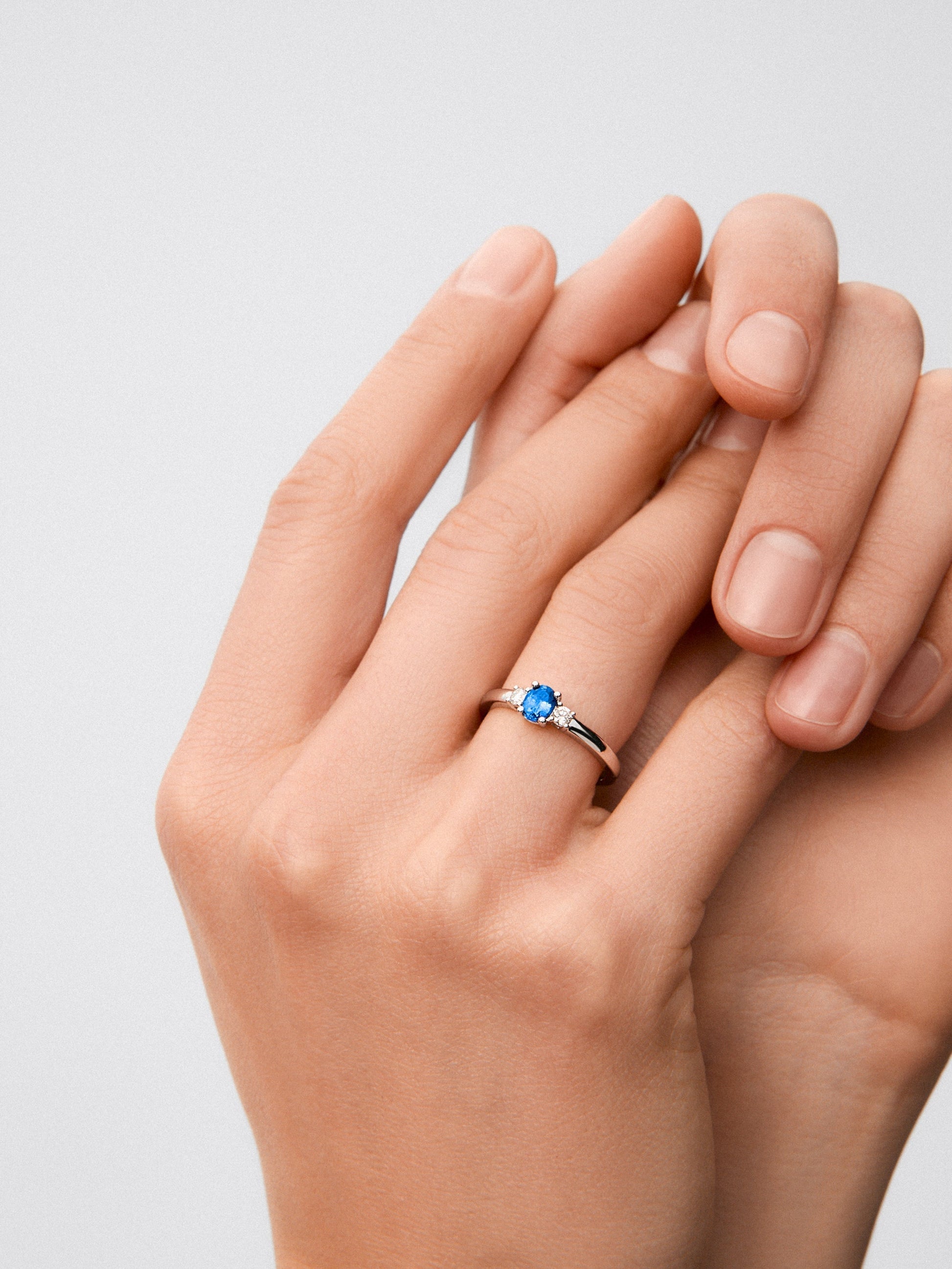 Anillo de oro blanco con zafiro azul en talla oval de 0,41 cts y diamantes en talla brillante con un total de 0,11 cts