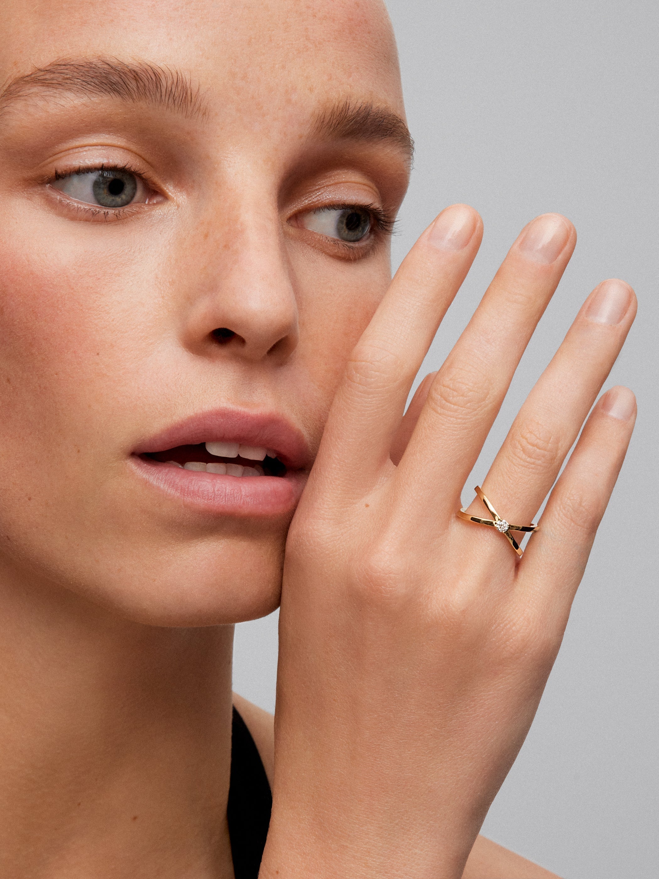 Anillo cruzado de oro amarillo de 18K con diamante en talla brillante de 0,12 cts