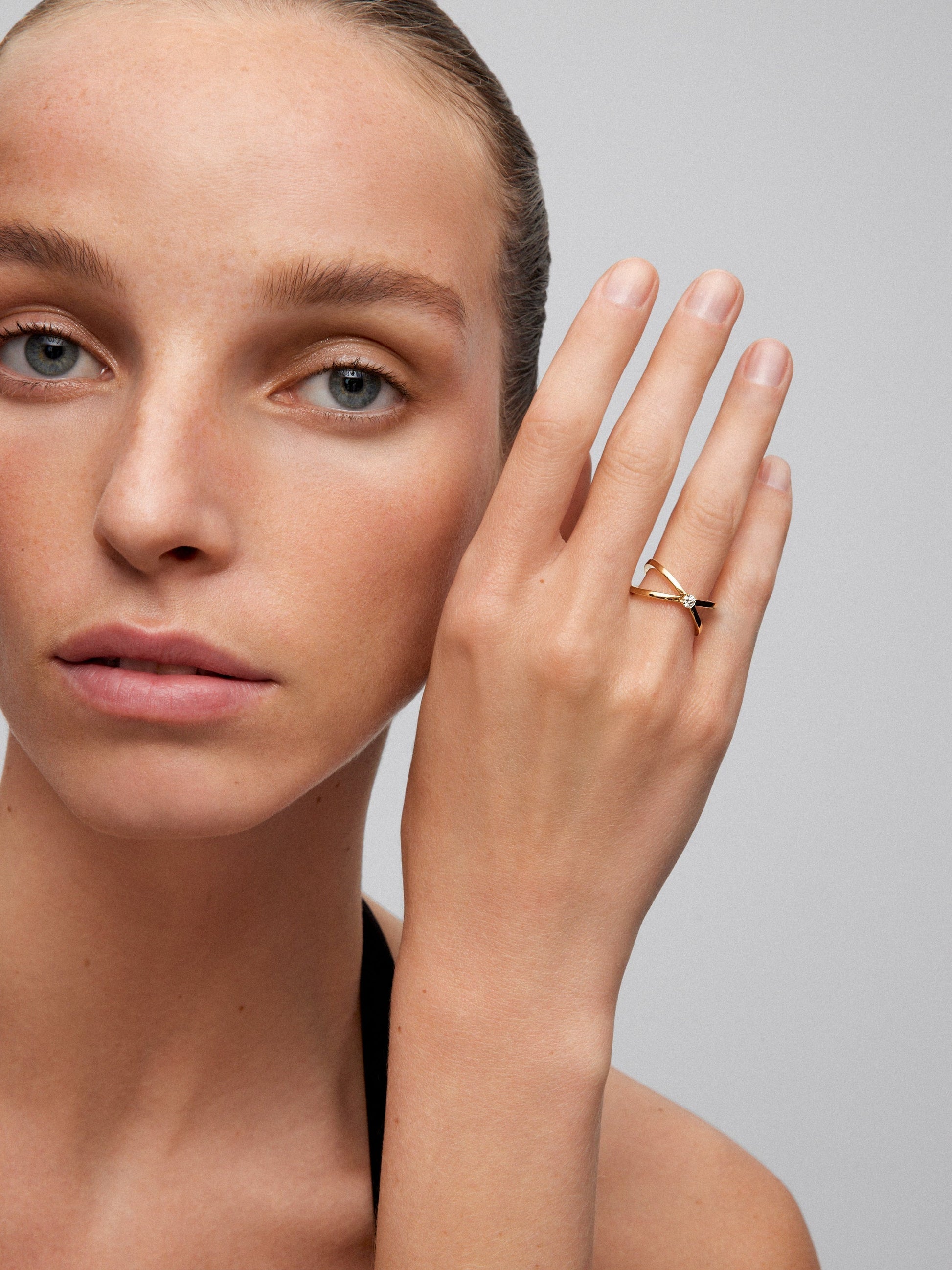 Anillo cruzado de oro amarillo de 18K con diamante en talla brillante de 0,12 cts
