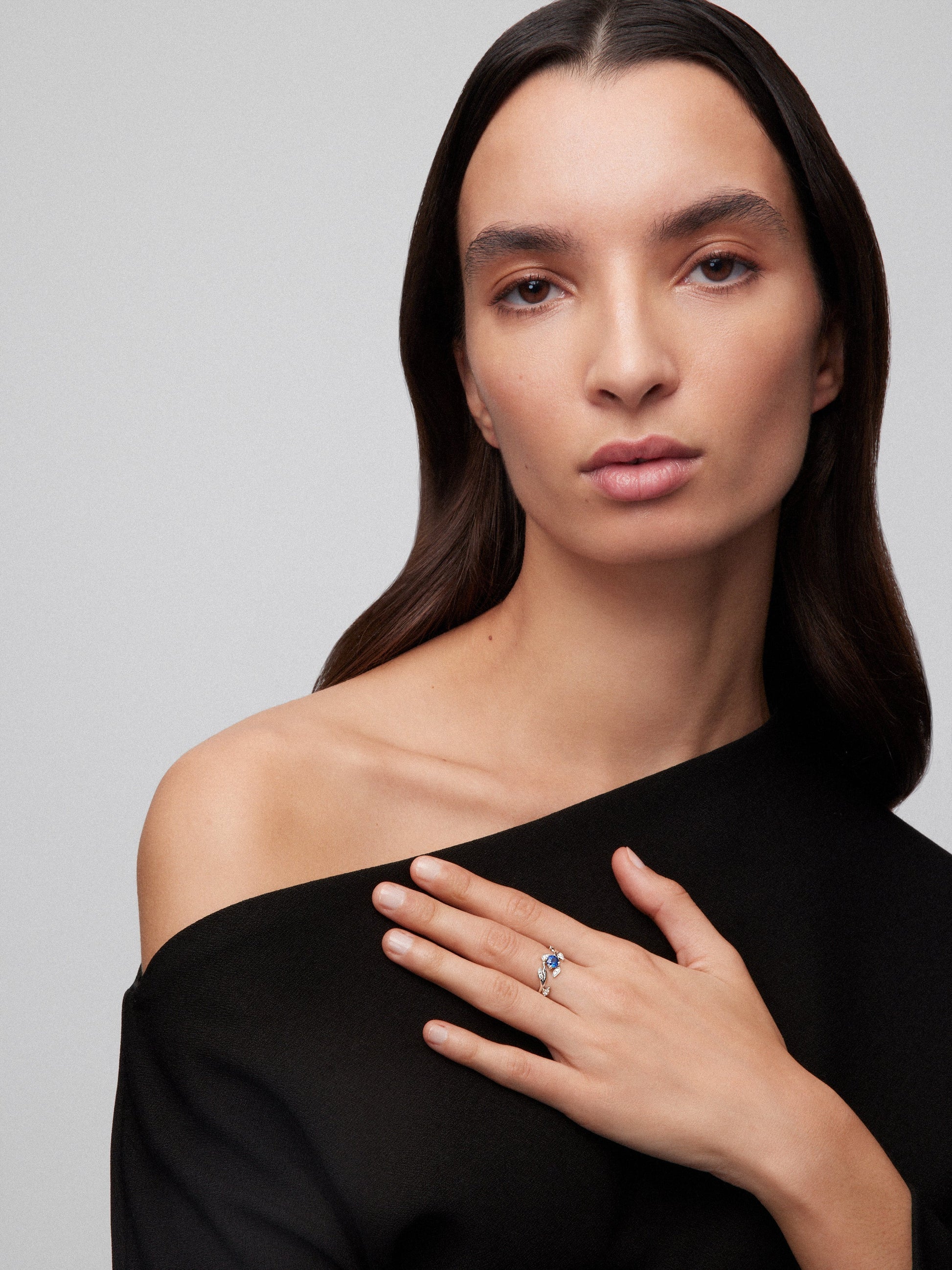 Anillo de oro blanco de 18K con zafiro azul en talla brillante de 0,46 cts y 12 diamantes en talla brillante con un total de 0,09 cts