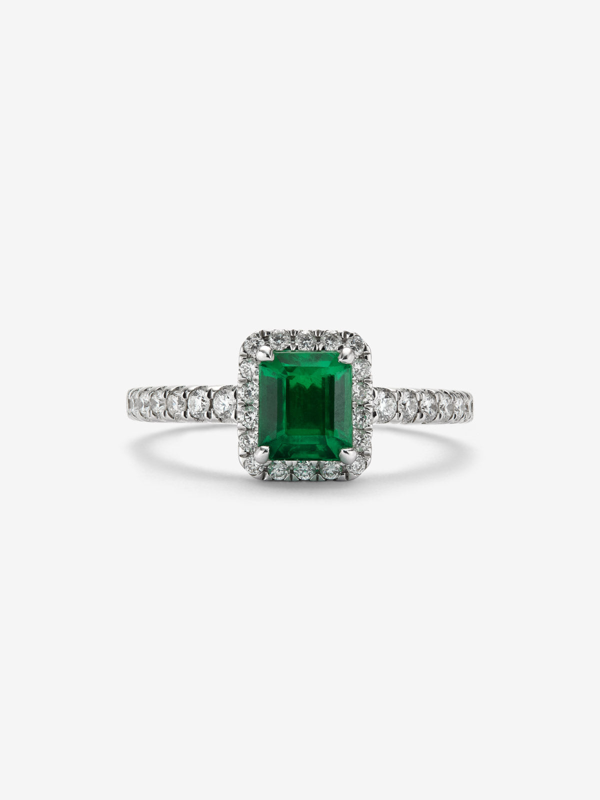 Anillo de oro blanco de 18K con esmeralda en talla esmeralda de 0,70cts y orla y brazo de 32 diamantes en talla brillante 