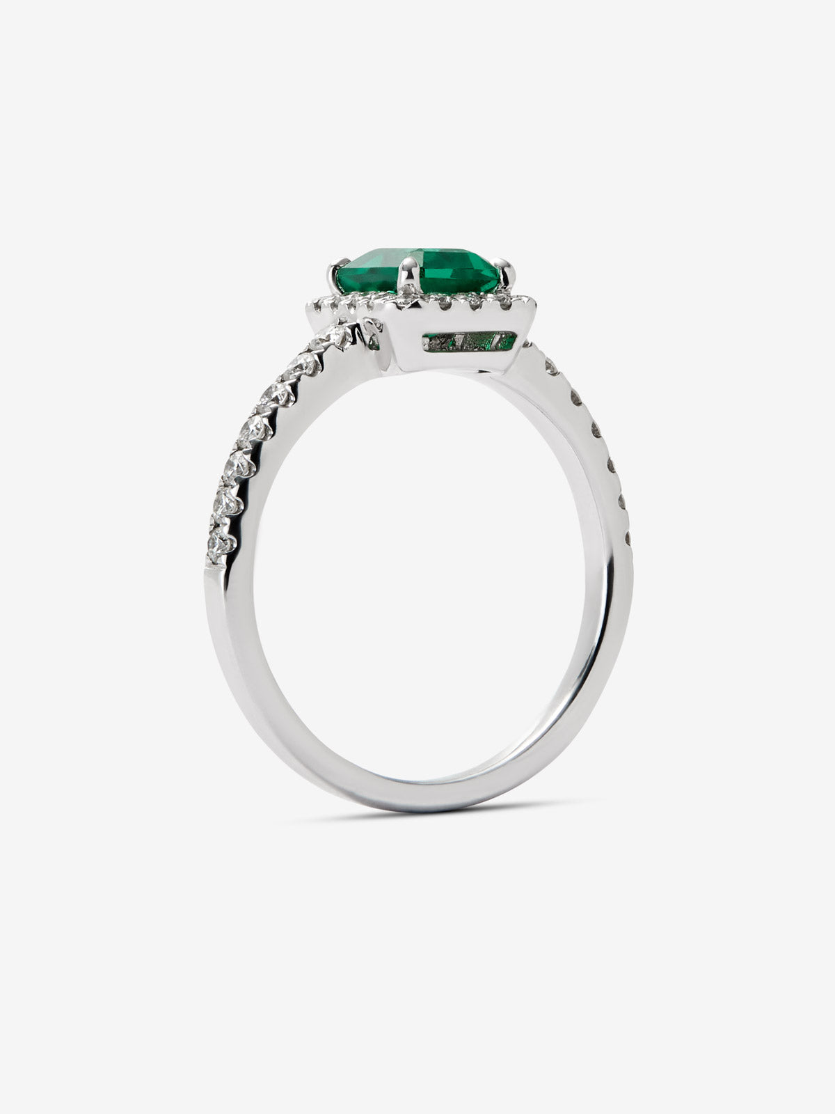 Anillo de oro blanco de 18K con esmeralda en talla esmeralda de 0,70cts y orla y brazo de 32 diamantes en talla brillante 