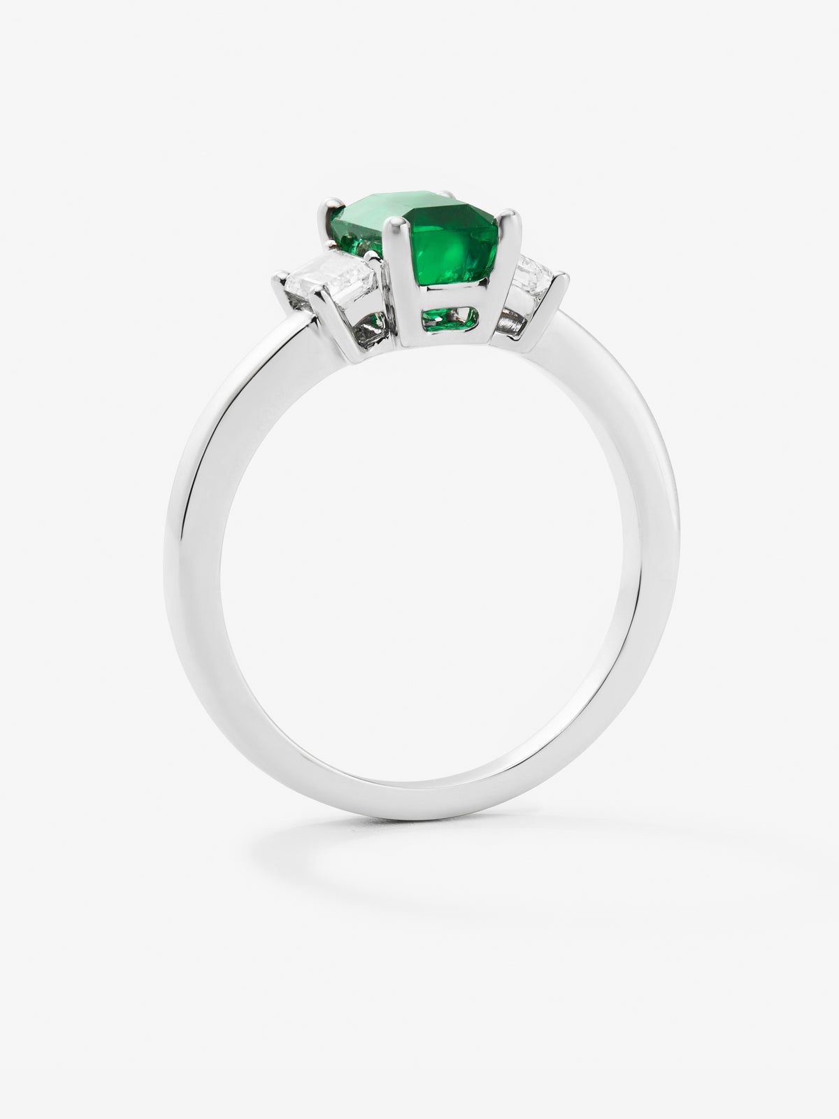Anillo tresillo de oro blanco de 18K con esmeralda en talla octogonal de 0,52 cts y 2 diamantes en talla esmeralda con un total de 0,35 cts