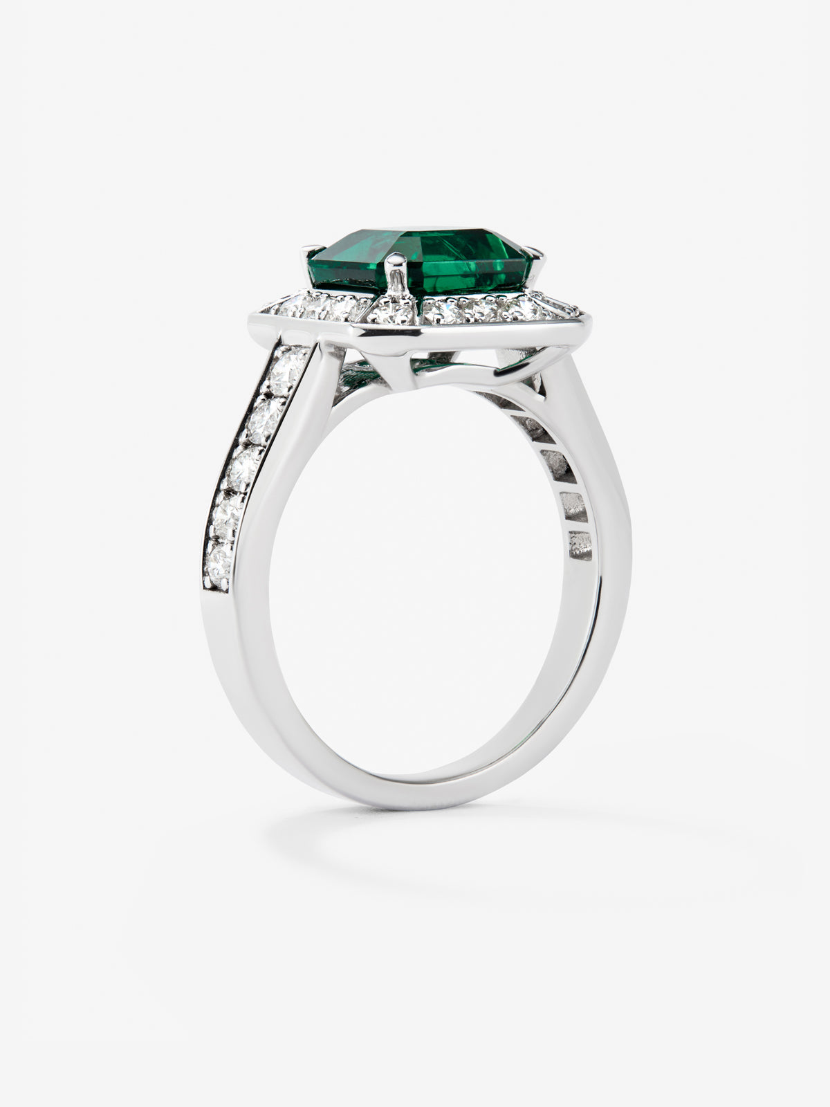 Anillo de oro blanco de 18K con esmeralda en talla esmeralda de 2,6 cts y orla y brazo de 26 diamantes en talla brillante con un total de 0,7 cts