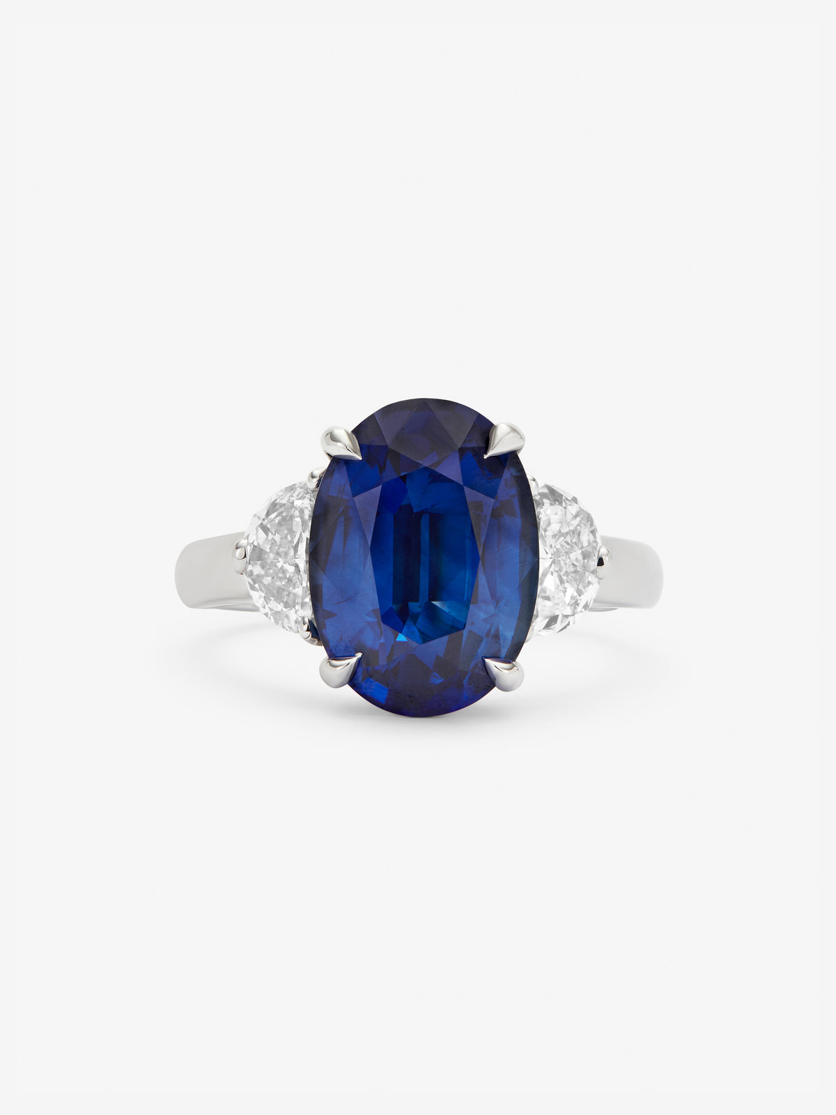 Anillo tresillo de oro blanco de 18K con zafiro azul en talla oval de 5,82 cts y 2 diamantes en talla fantasía con un total de 0,98 cts