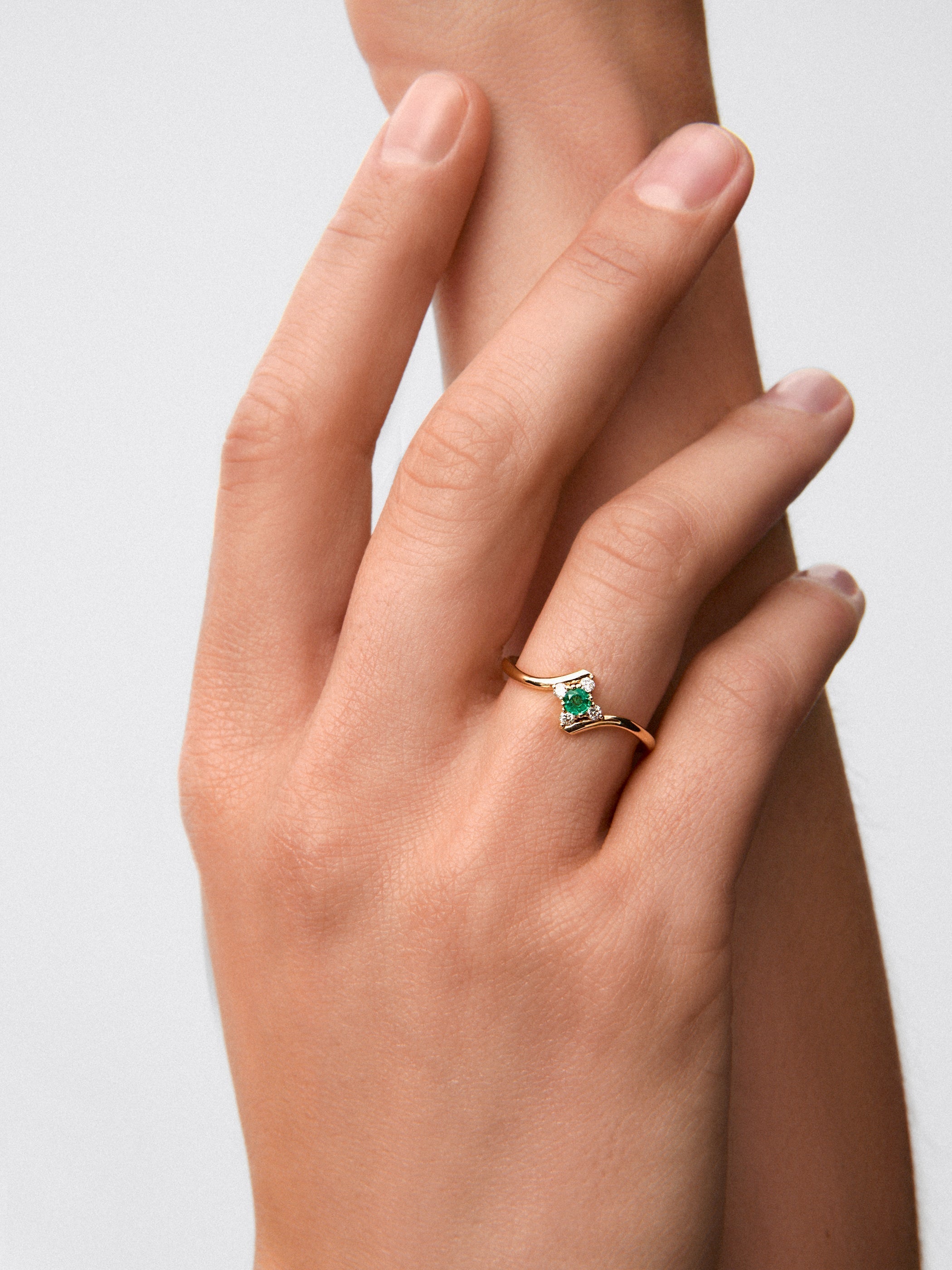 Anillo de oro amarillo de 18K con esmeralda verde en talla brillante de 0,088 cts y 4 diamantes en talla brillante con un total de 0,08 cts