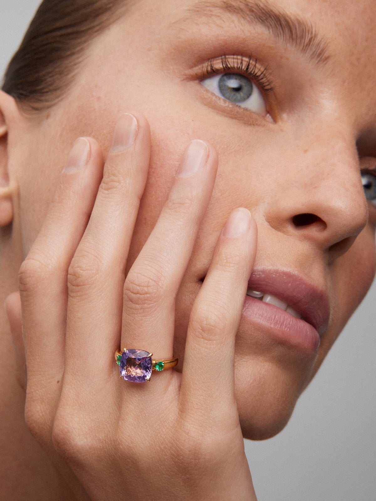 Anillo tresillo de oro amarillo de 18K con amatista morada en talla cushion de 3,53 cts y 2 esmeraldas verdes en talla brillante con un total de 0,19 cts