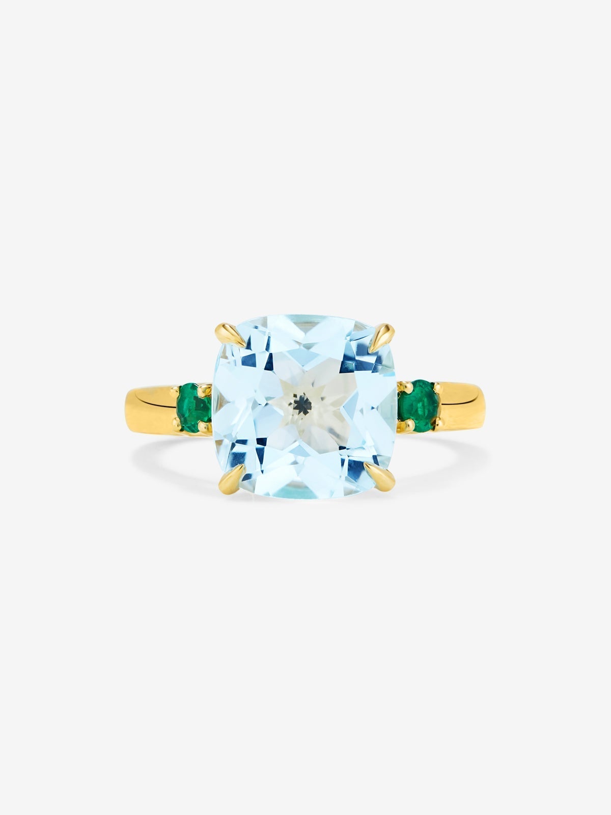 Anillo tresillo de oro amarillo de 18K con topacio azul sky en talla cushion de 4,88 cts y 2 esmeraldas verdes en talla brillante