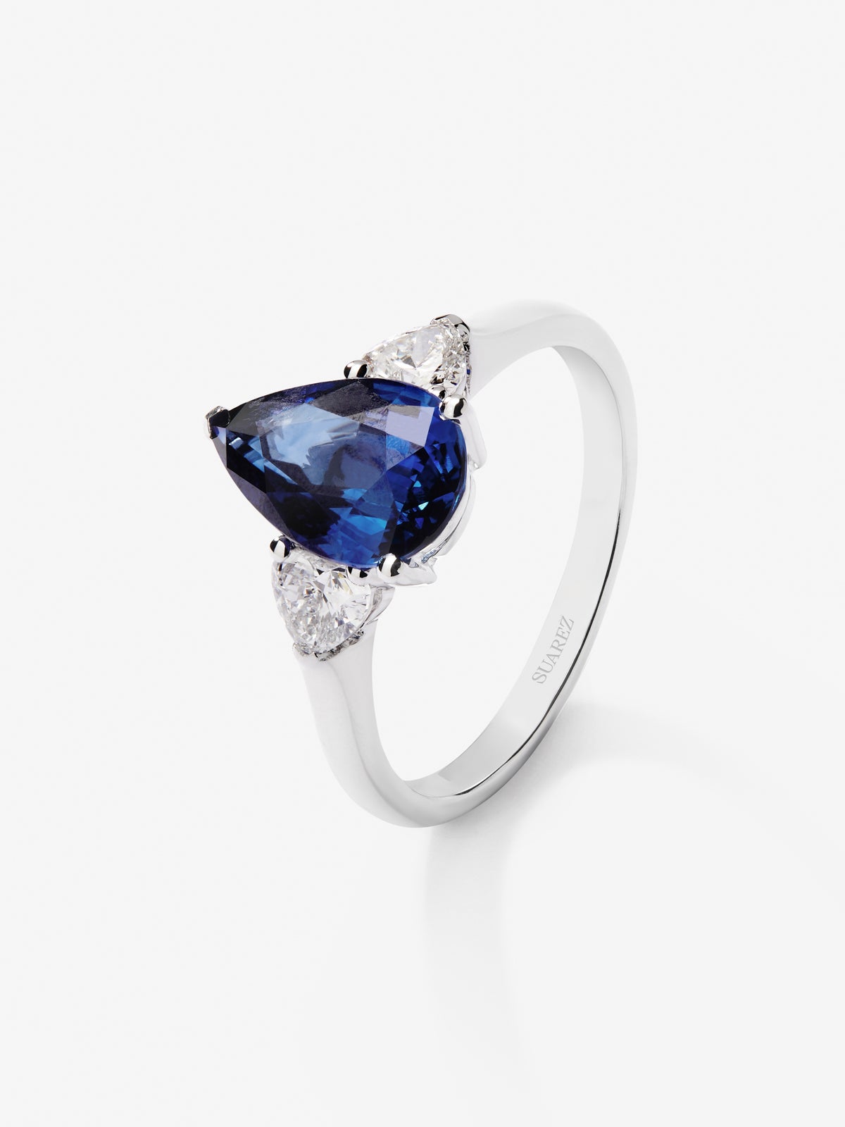 Anillo de oro blanco de 18K con zafiro azul royal en talla pera de 2,54 cts y 2 diamantes en talla corazón con un total de 0,38 cts