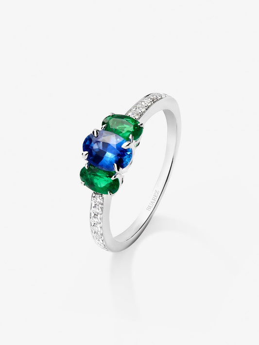 Anillo tresillo de oro blanco de 18K con zafiro azul en talla oval de 0,7 cts, esmeraldas verdes en talla oval de 0,41 cts y diamantes blancos en talla brillante de 0,115 cts