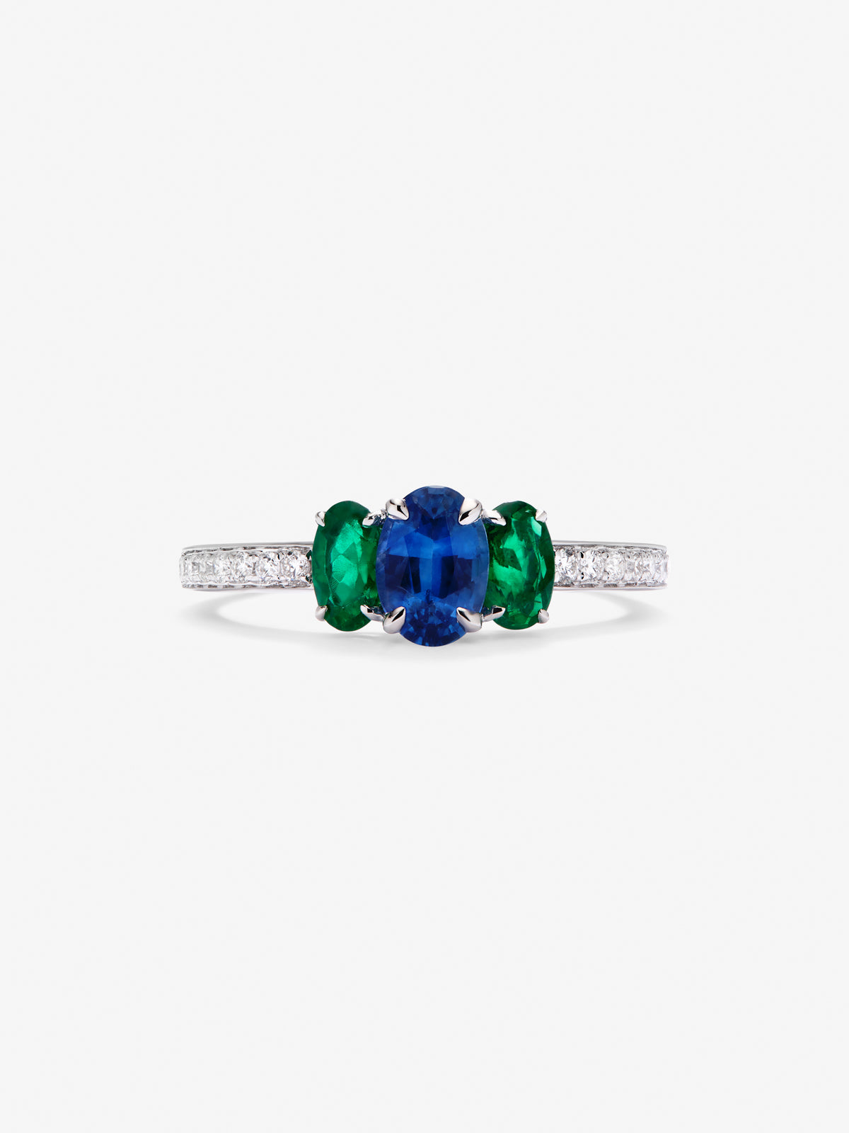 Anillo tresillo de oro blanco de 18K con zafiro azul en talla oval de 0,71 cts, 2 esmeraldas verdes en talla oval con un total de 0,5 cts y 10 diamantes en talla brillante con un total de 0,115 cts