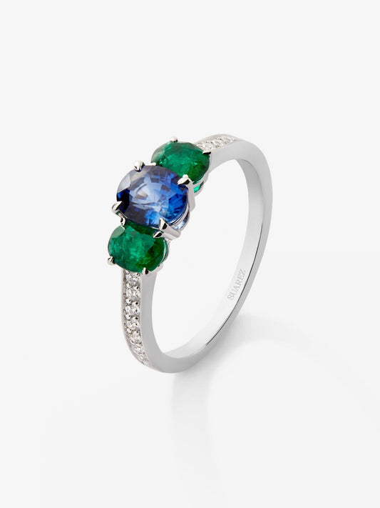 Anillo tresillo de oro blanco de 18K con zafiro azul en talla oval de 0,97 cts, esmeraldas verdes en talla oval de 0,63 cts y diamantes blancos en talla brillante de 0,14 cts