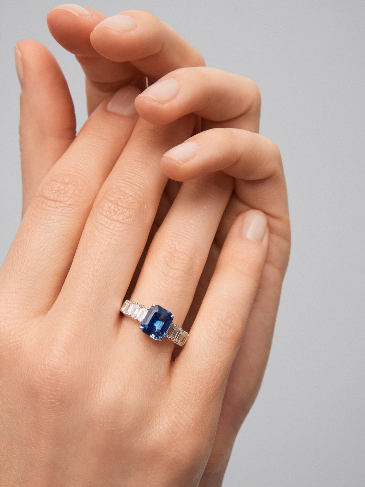 Anillo solitario de oro blanco de 18K con zafiro azul en talla octogonal de 3,11 cts y 8 diamantes en talla esmeralda con un total de 1,24 cts